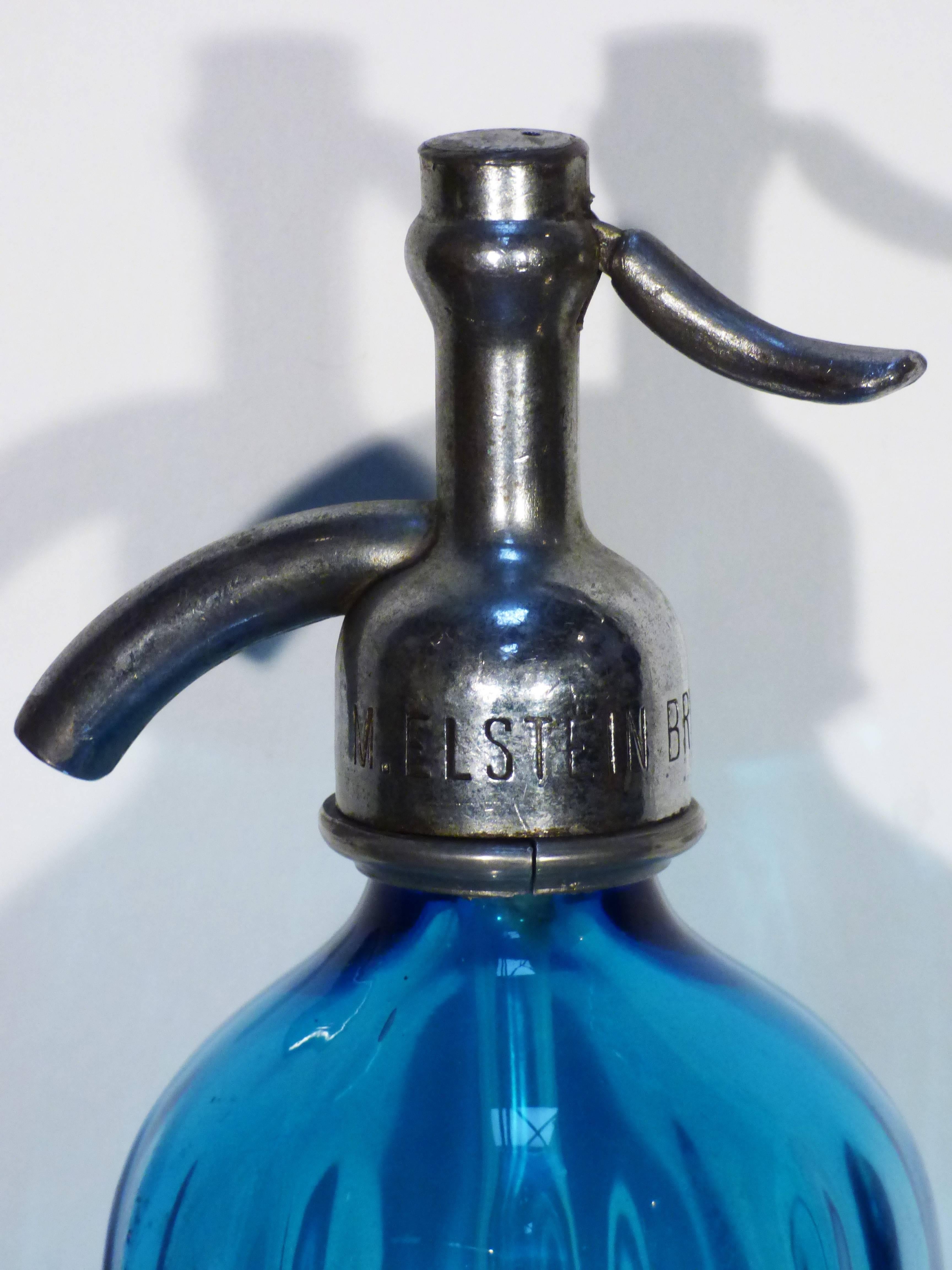 A rare original soda glass bottle from Brooklyn, New York.
Markings included to the metal nozzles and etched to the front. 
The bottle is in good vintage condition, wear consistent with age.
