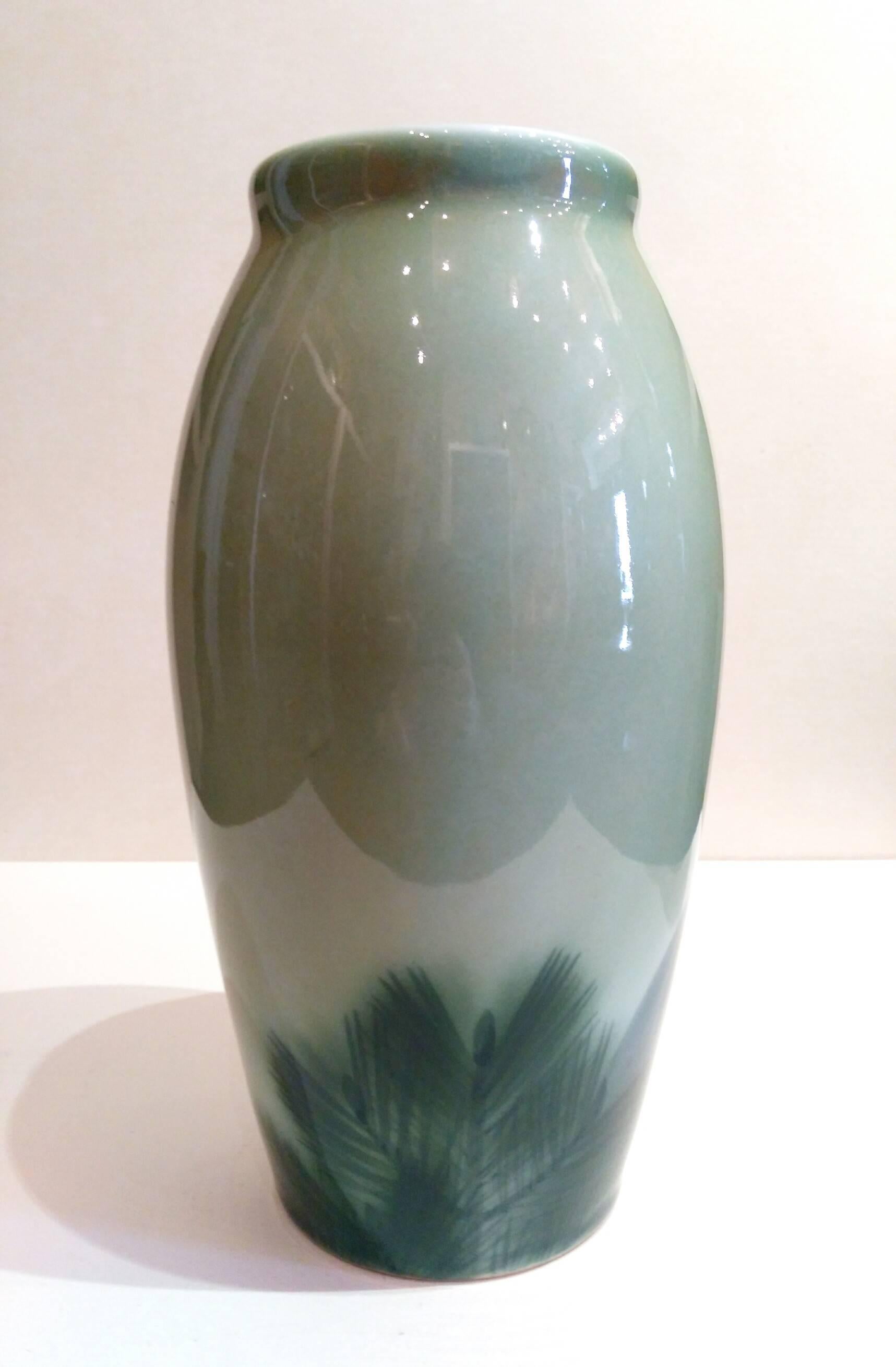 A vase depicting a Manchurian crane and a pine on a celadon background by Nishiura Enji.