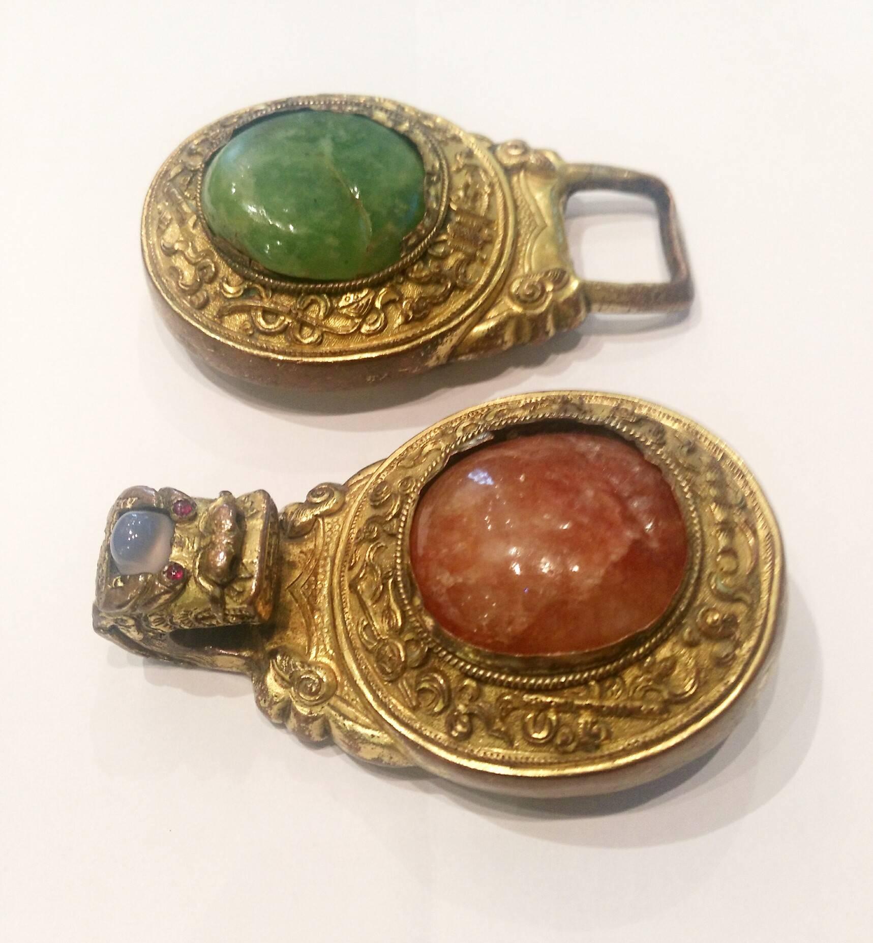 Hardstone inlaid gilt belt buckle.

Gilt bronze scrolled bases mounted with sunstone and sapphire on one side and pale green hardstone on the other.