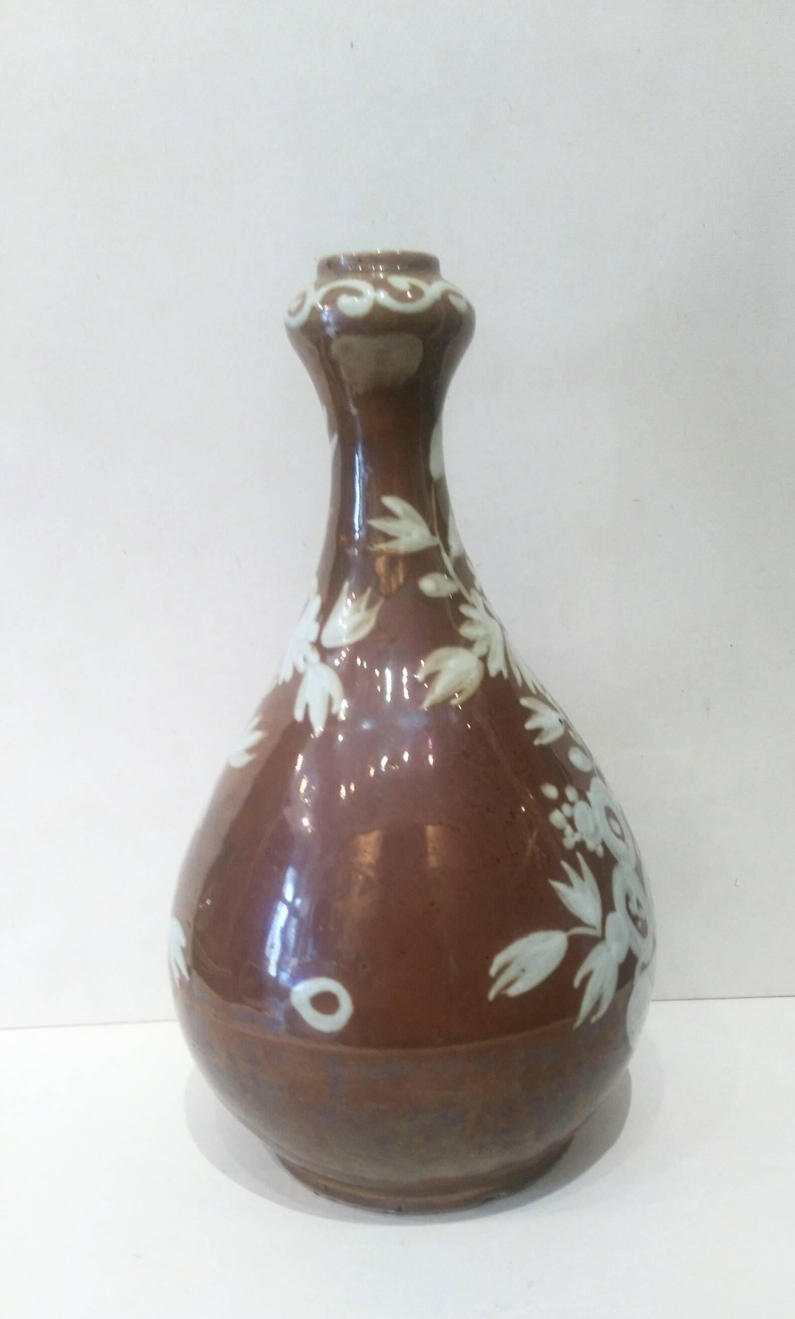 A bottle with garlic bulb shaped mouth, toffee-colored glaze and white slip decoration.
Jingdezhen, Jiangxi province,
China, Ming dynasty, circa 1573-1620.

Similar vase is illustrated in 