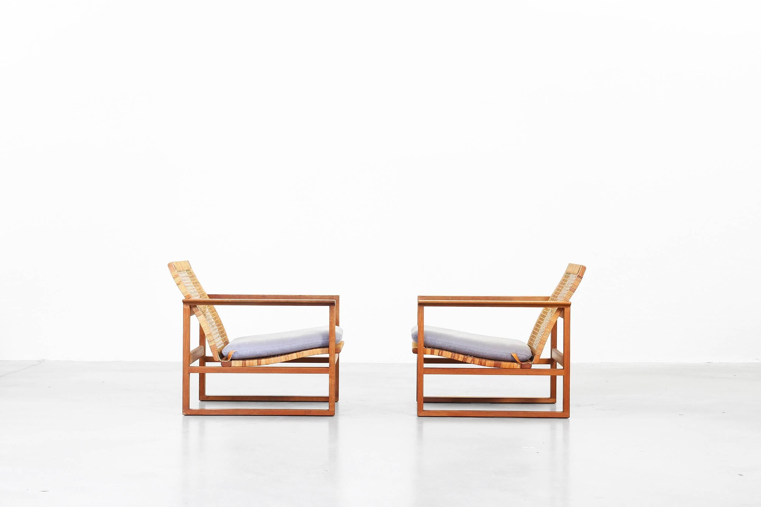 This model no 2256 lounge chair was designed in 1956 by Børge Mogensen for Fredericia. It features a cubical frame made from solid oak. This rare version comes with a caned back! The seat cushions were newly reupholstered with a high quality fabric