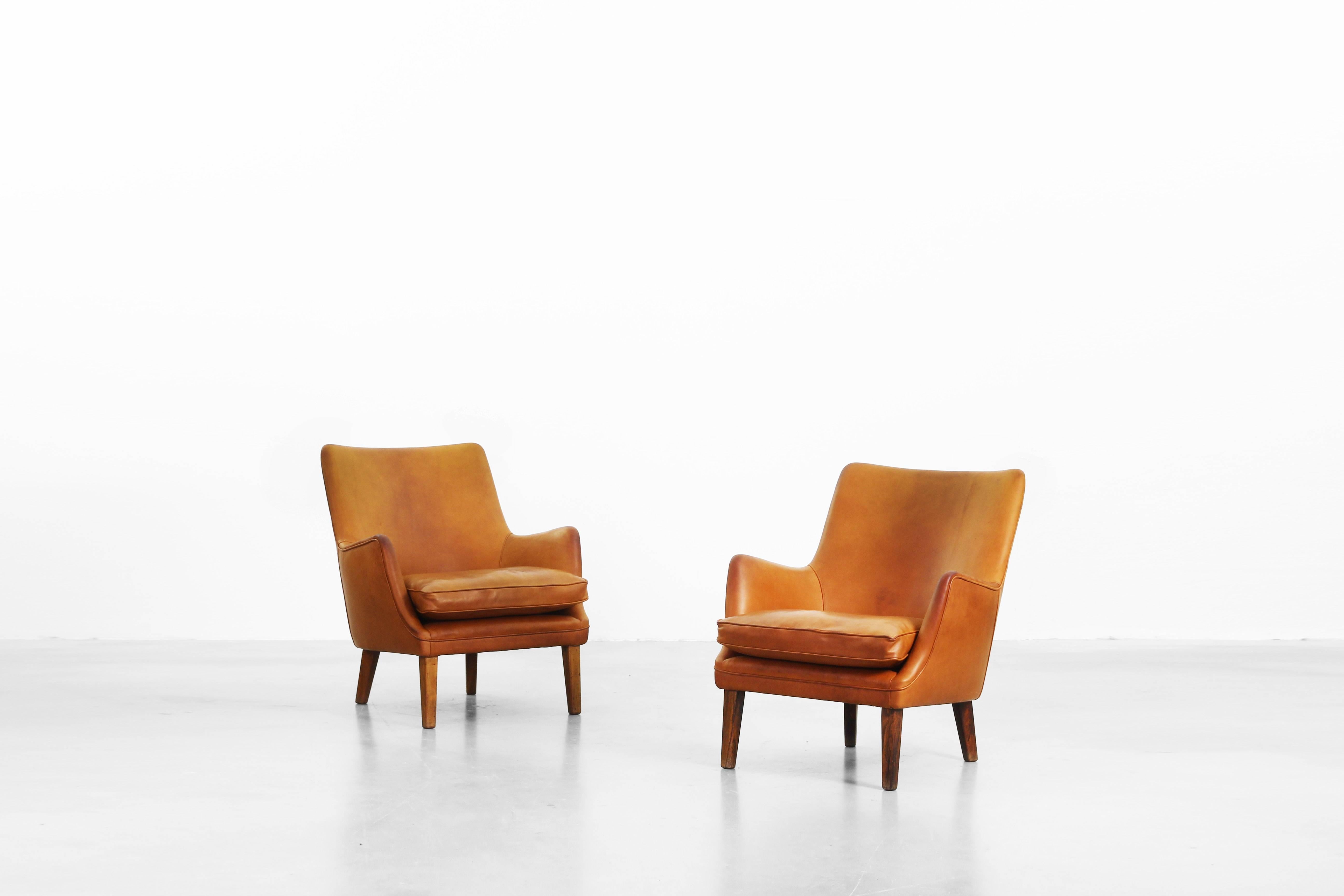 Very beautiful pair of lounge chairs designed by Arne Vodder for Ivan Schlechter.
Both lounge chairs come with brown-cognac leather and dark wood legs. The condition of both is in a very good excellent condition.
   