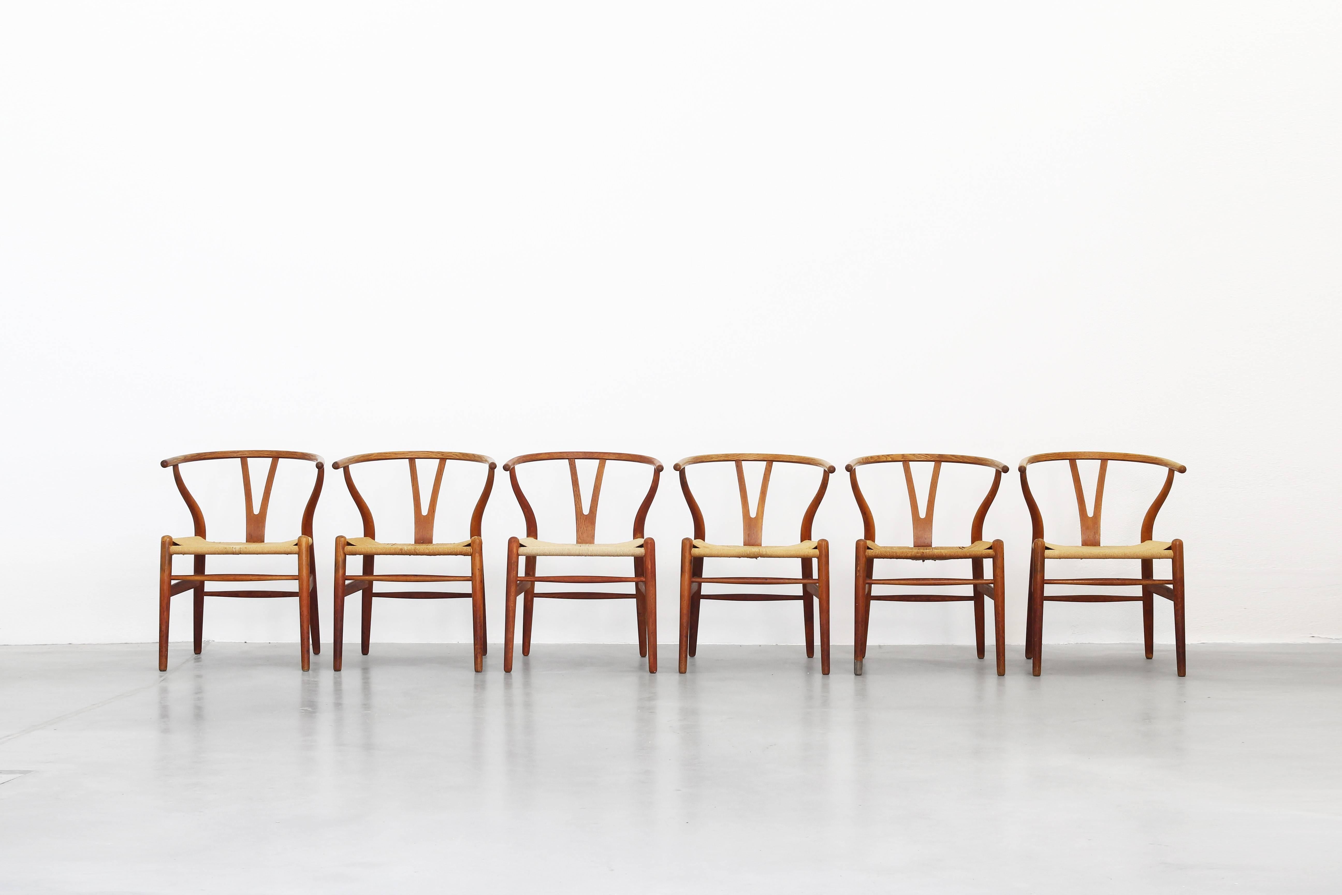A beautiful set of six old dining chairs Mod. Wishbone CH24, designed by Hans J. Wegner for Carl Hansen. All chairs are in a good used condition and all came with a beautiful patina. The frame is made of oak and three seats were newly covered with