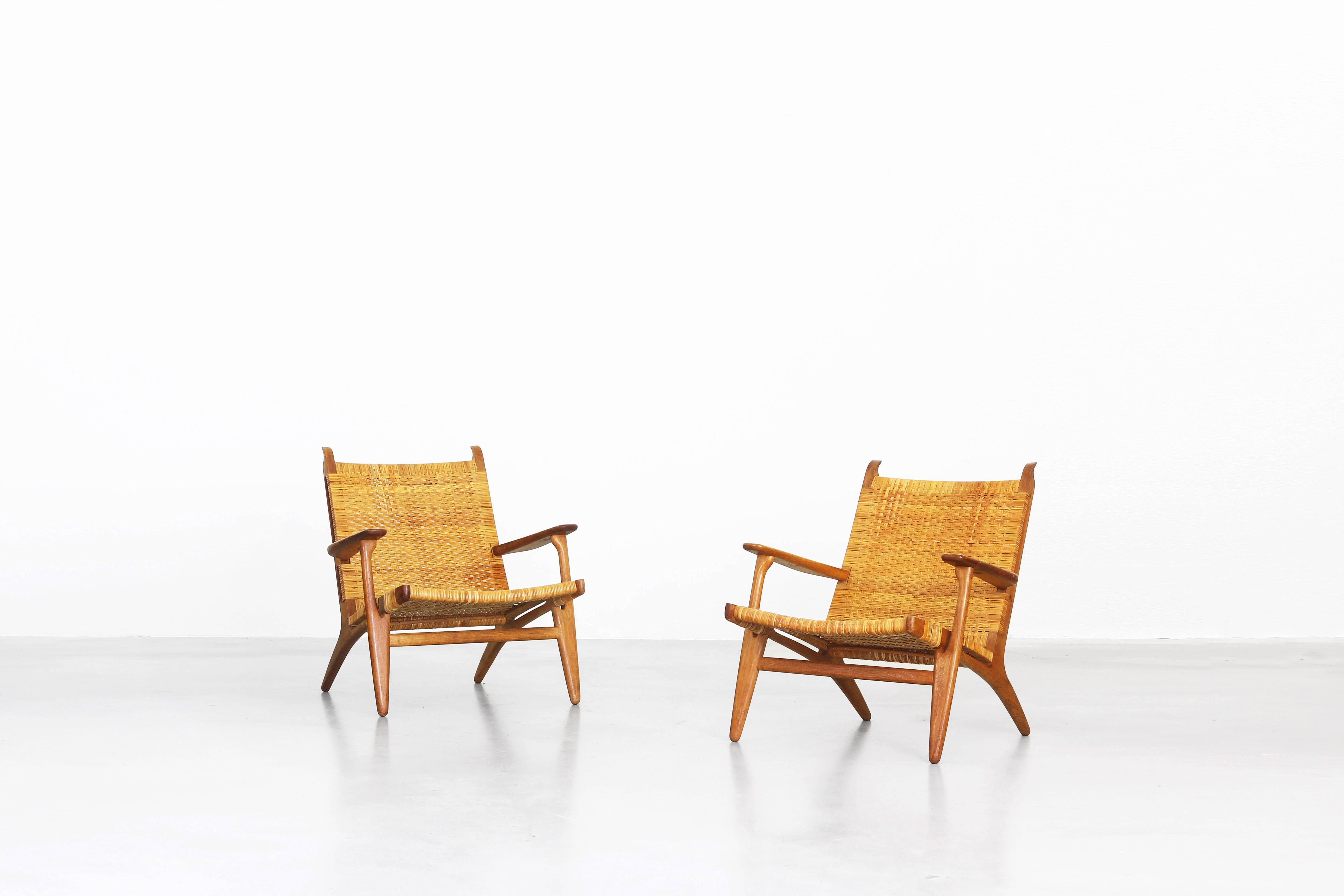 A very beautiful and rare pair of lounge chairs designed by Hans J. Wegner for Carl Hansen in 1949, Denmark. Both lounge chairs are in a very good condition with just little traces of usage. They come with a great patinated oakwood frame and a woven