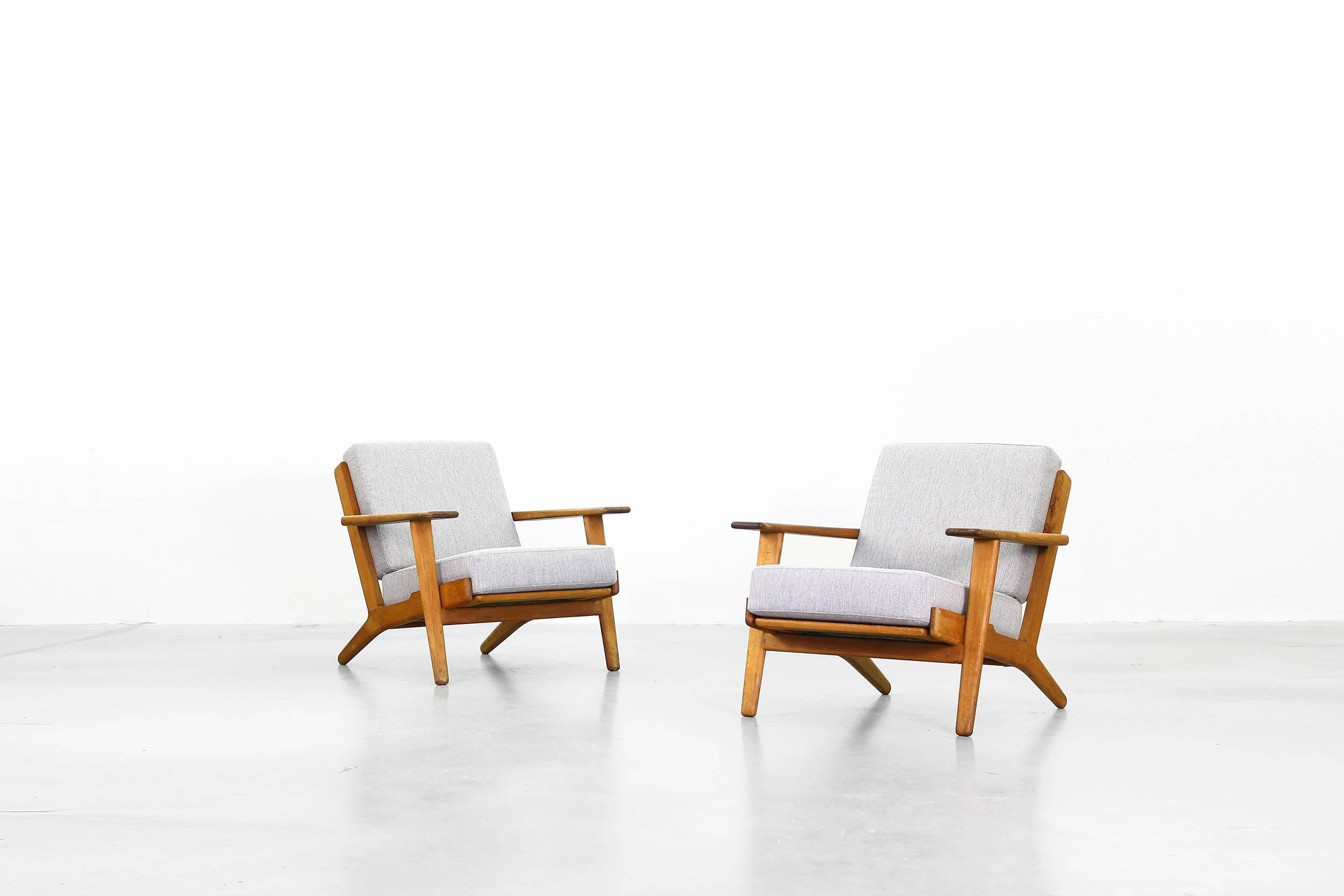 Beautiful pair of lounge chairs by Hans J. Wegner for GETAMA in 1960s, made in Denmark.
Both lounge chairs are in a beautiful condition with just little traces of usage. They are made of oak and were newly reupholstered in a dark grey high quality