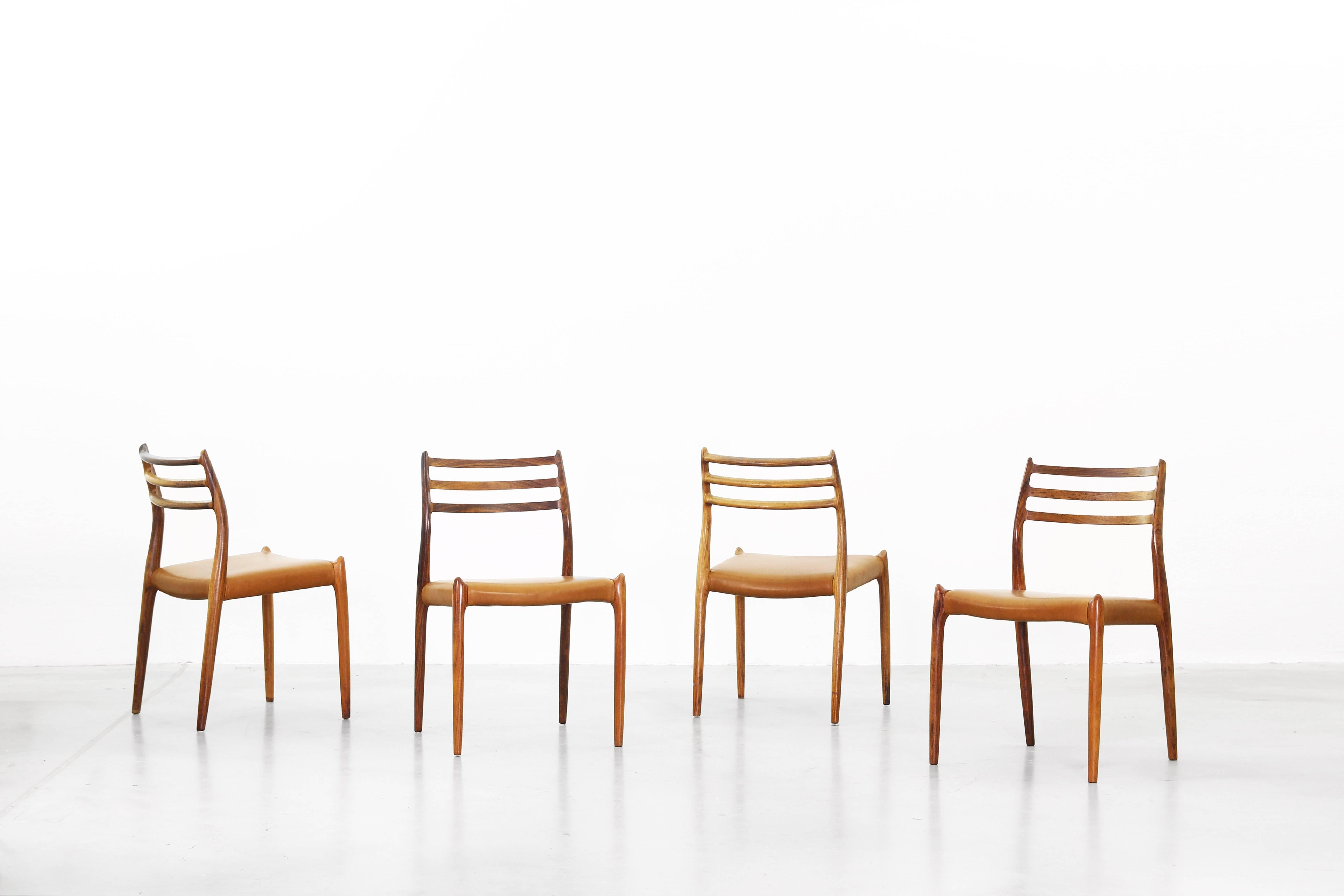 A set of beautiful dining chairs by Niels Møller Mod. 78 (old version), made in Denmark. All chairs are in an excellent condition and are made of dark wood and brown-cognac leather.