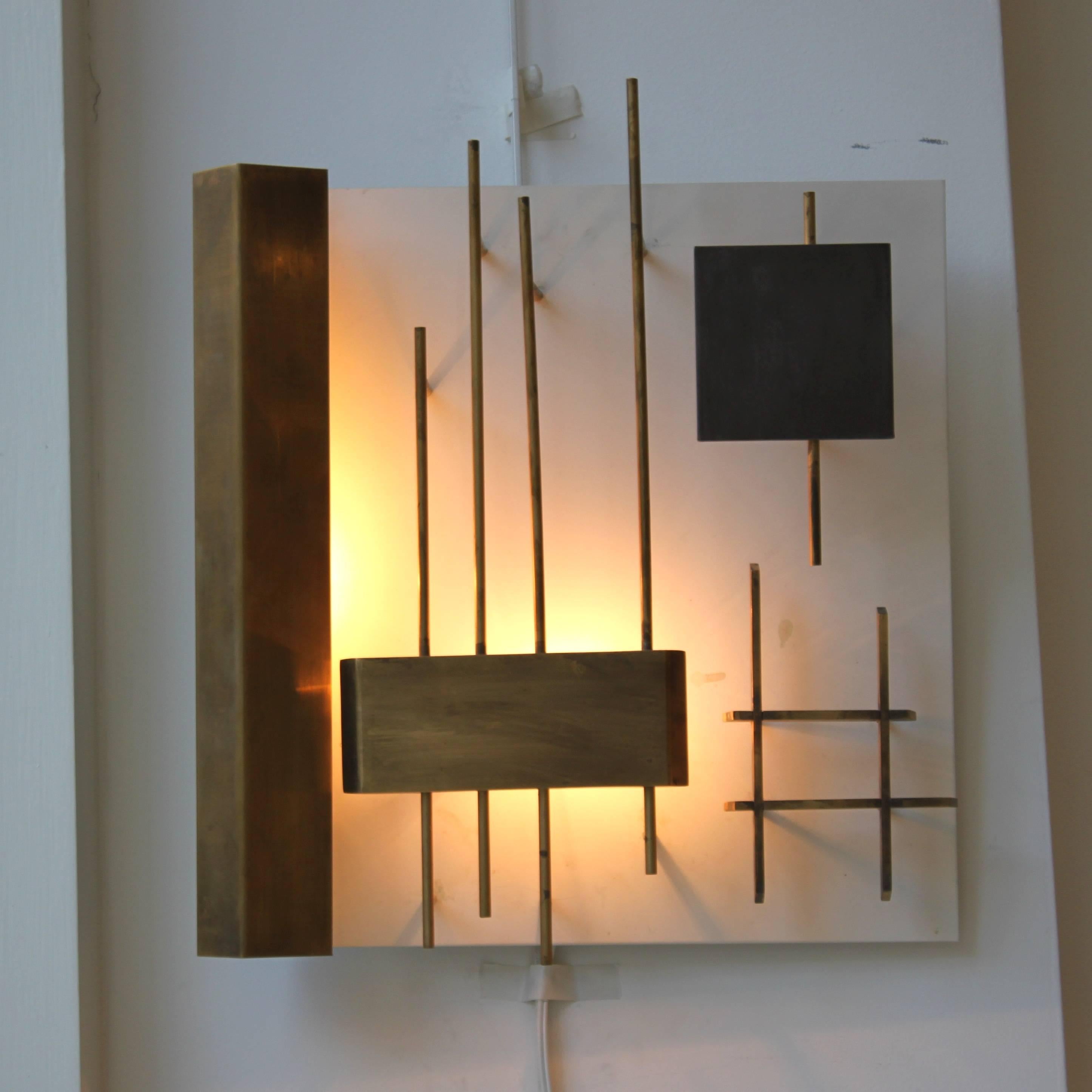 Two brass wall lights by Gio Ponti designed and made in Italy in early 1960s.

Produced by Lumi. Model number 575.

Published.

These two wall lamps have brass and painted geometric elements set on a white painted backplate. One has a single