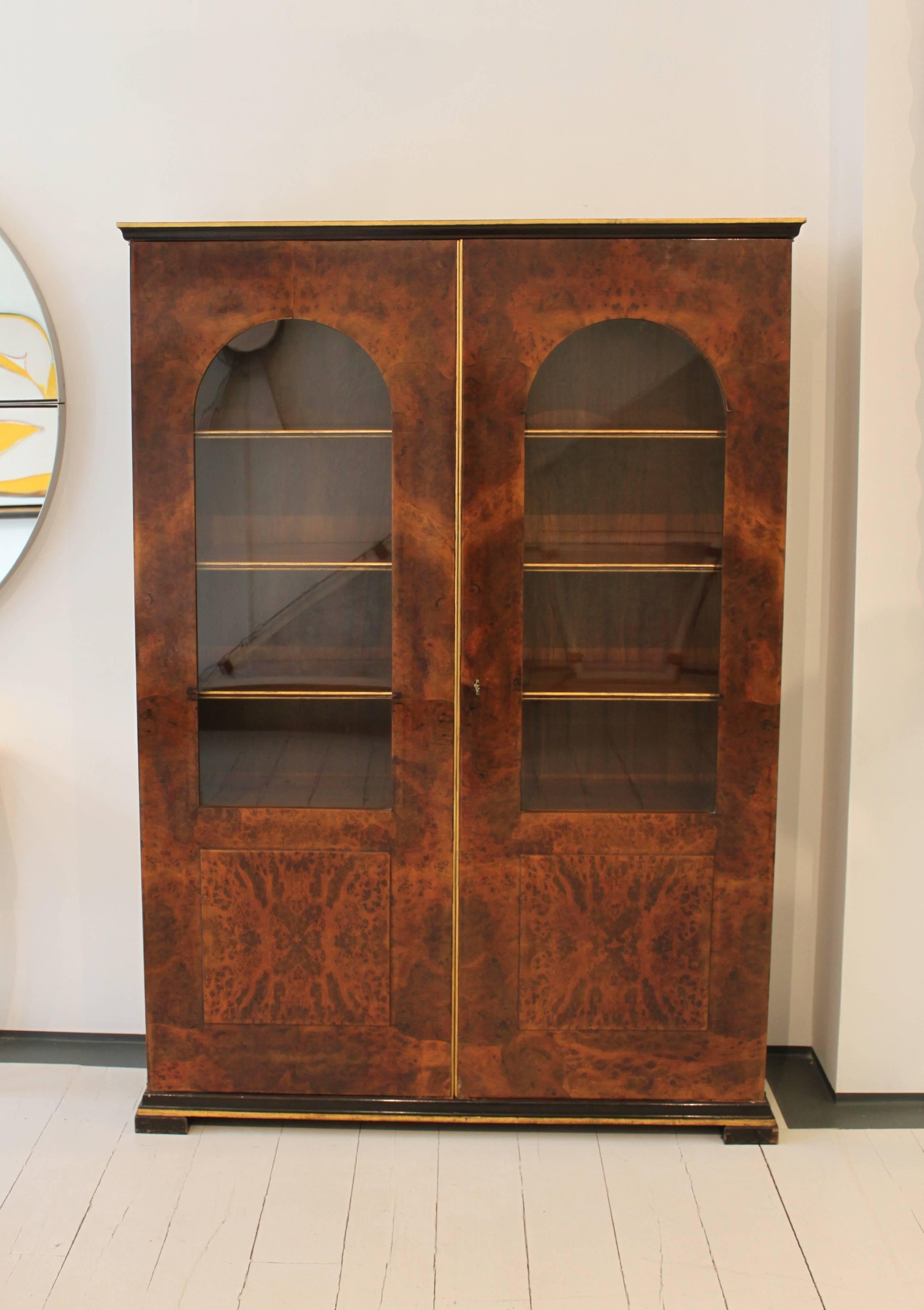 Pair of glazed bookcases in Italian root walnut with gilt details.
From a suite designed as a rare collaboration of Buzzi and Gio Ponti.