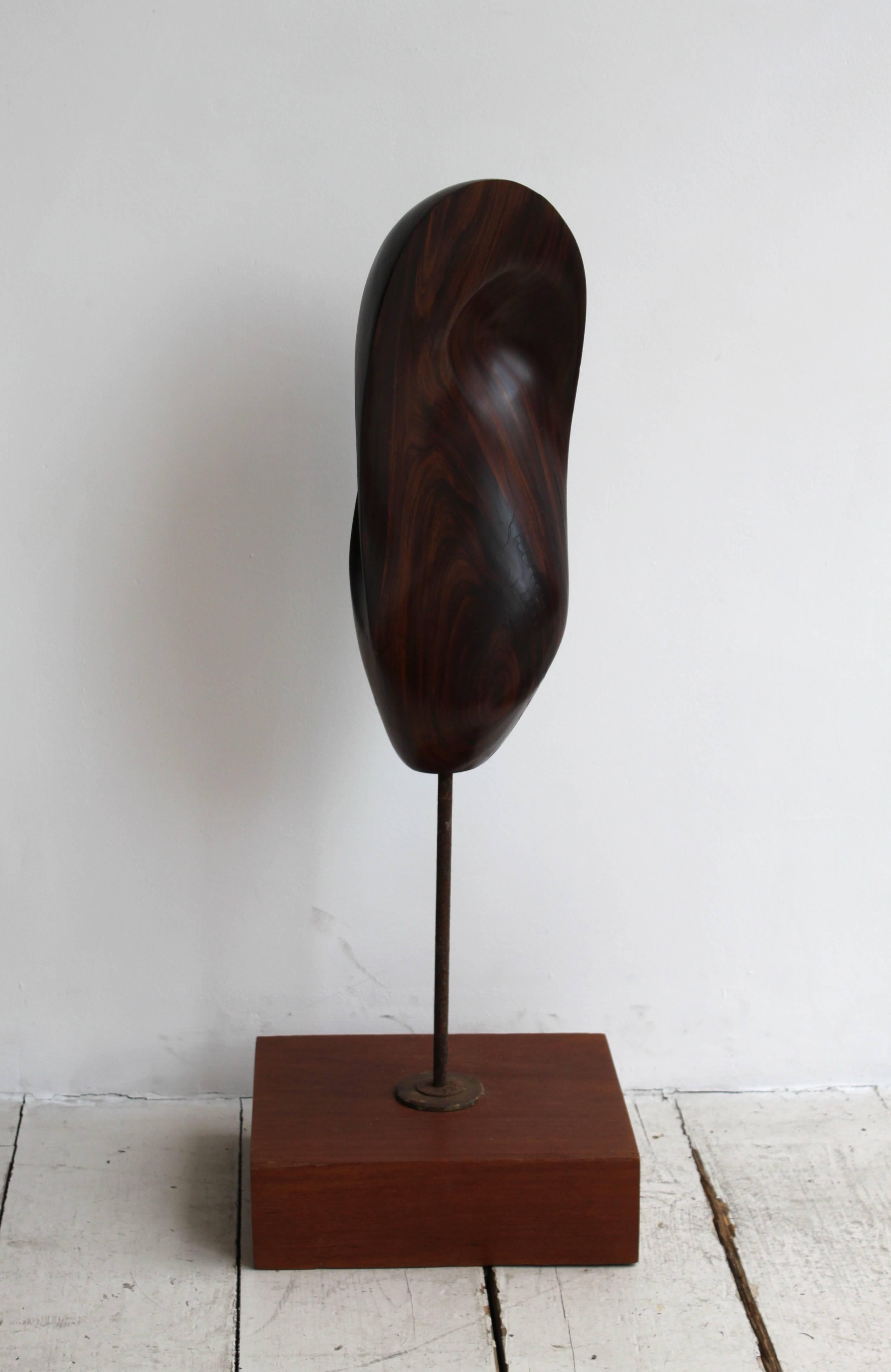 Bertram Eaton (1912-1978).
Curved and rounded form.
1960s.

Carved lignum vitae sculpture on a metal rod and wooden base.
 