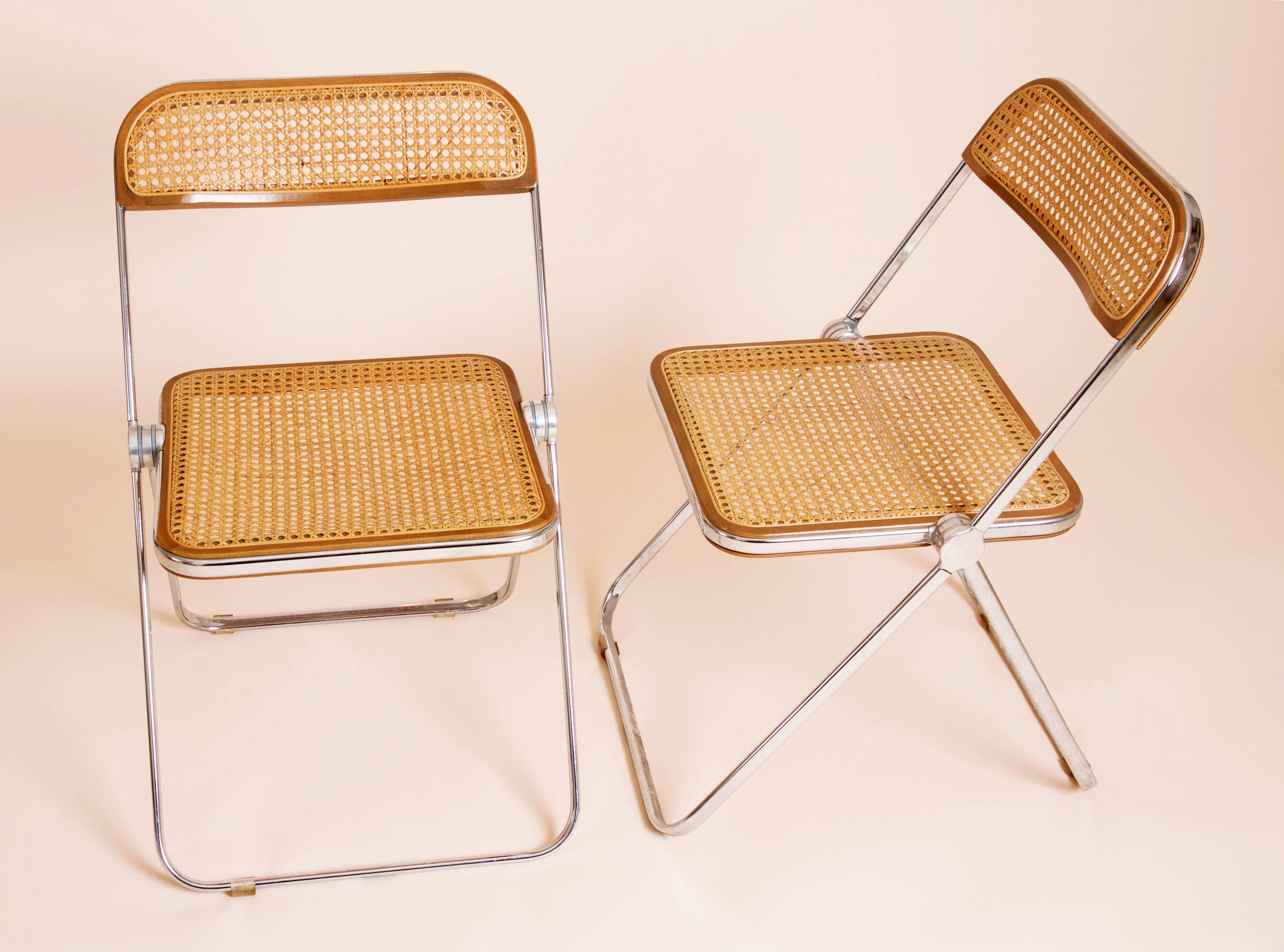Rare set of ten 'Plia' folding chairs designed by Giancarlo Piretti for Castelli in 1969. 
The seat is made of chrome frame with beige caning seating and back. 
The caning is also framed and fixed to the chrome by a beautiful wooden contour, that