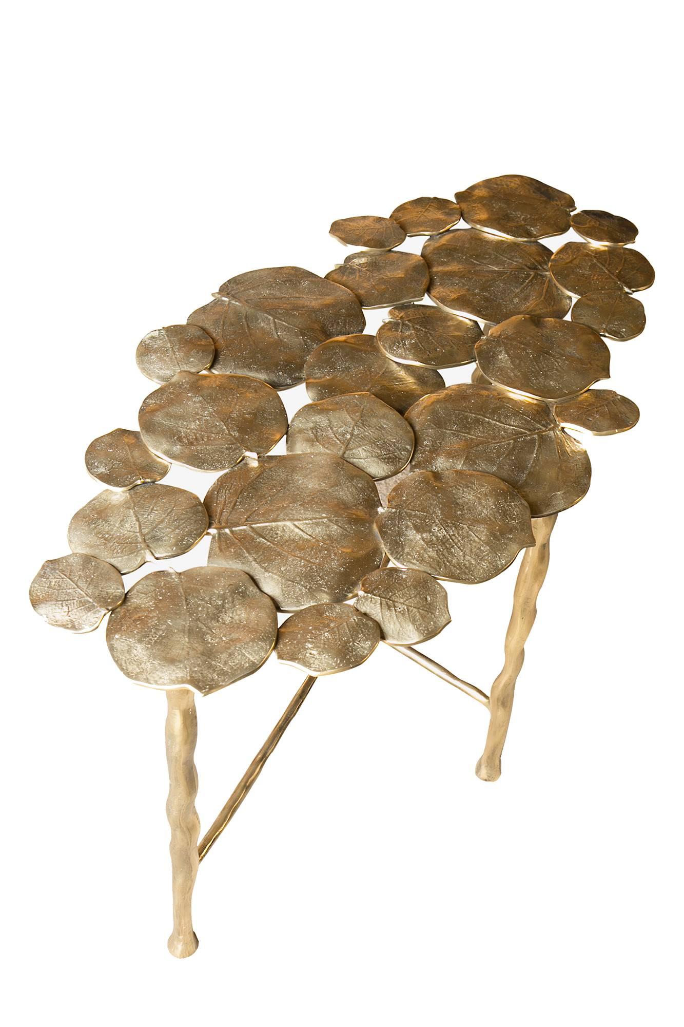 Decorative oval side table made in France. A unique cocktail or occasional table consisting of individually moulded cast brass leaves with brass legs.
