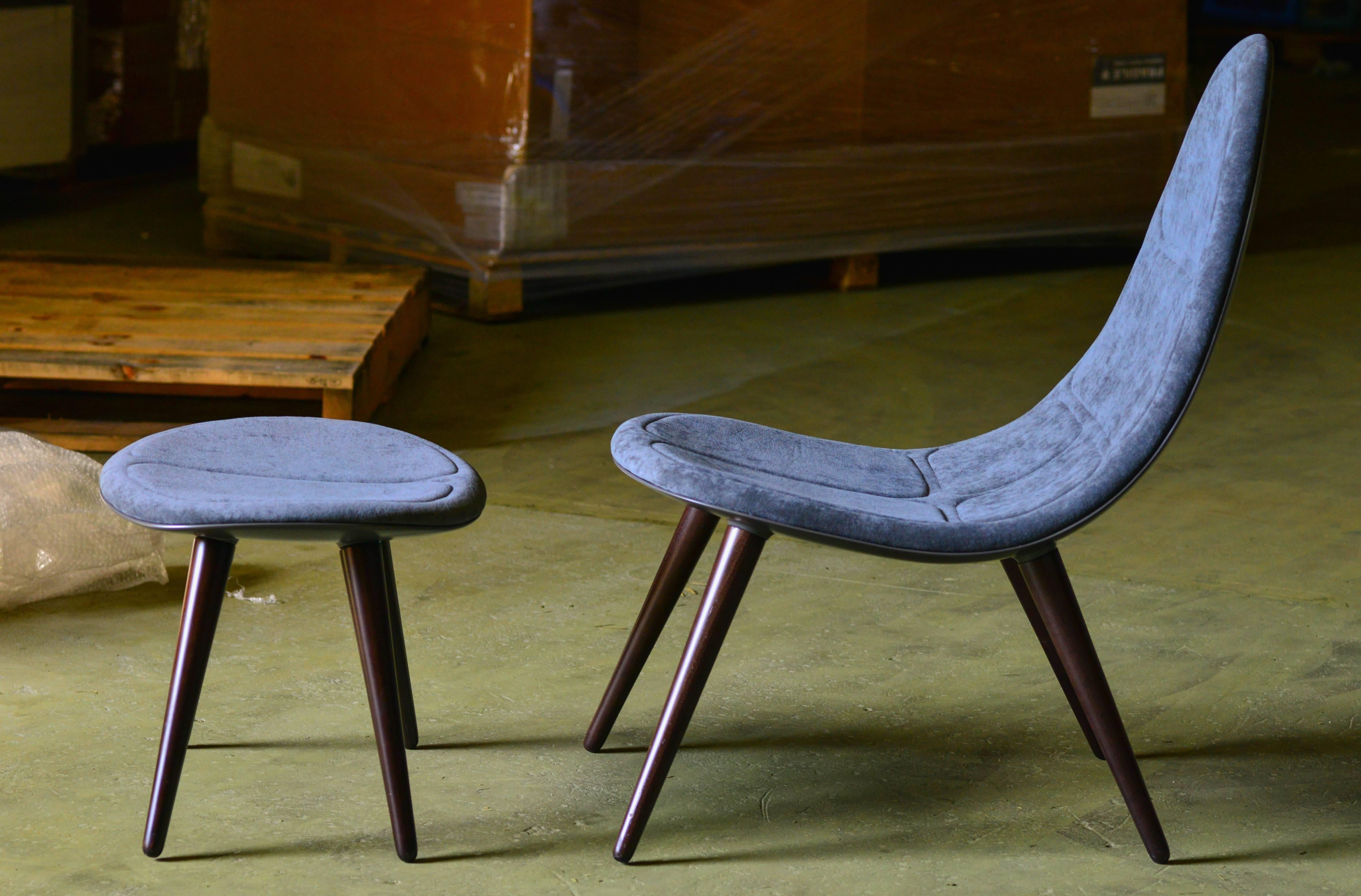 A contemporary lounge chair with a 1960s futuristic touch, this chair and ottoman are artisanally produced using a mix of materials-a moulded structure in fibre and resin and FR foam, ergonomic yet slim-lined. Upholstered in commercial grade heavy
