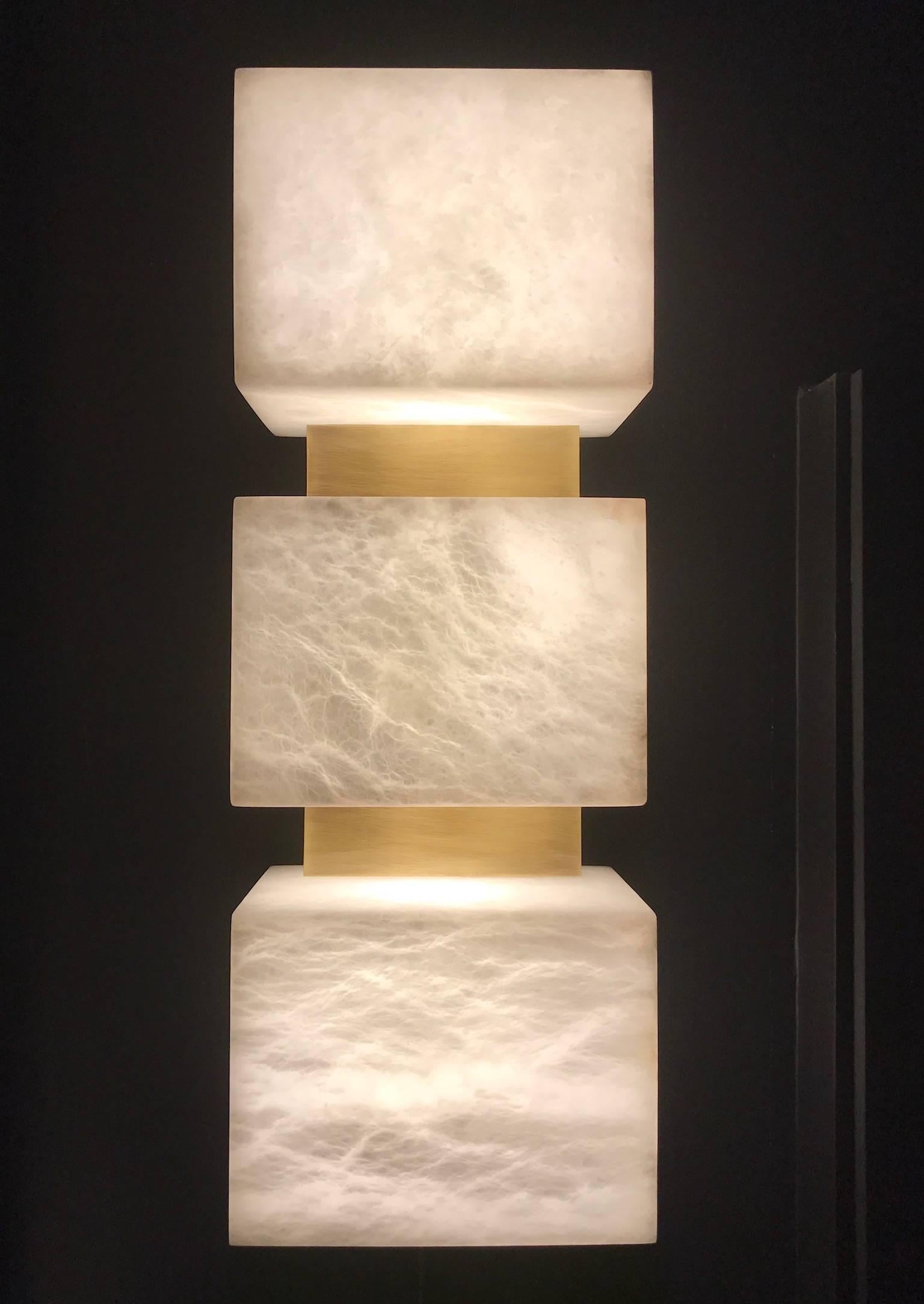 Designed by Simon Stewart for Charles Burnand the Scatola wall sconce is made from alabaster with brushed patinated brass.

Alabaster has a unique fluidity to its appearance when back lit. Being a natural material, each piece is unique. The degree