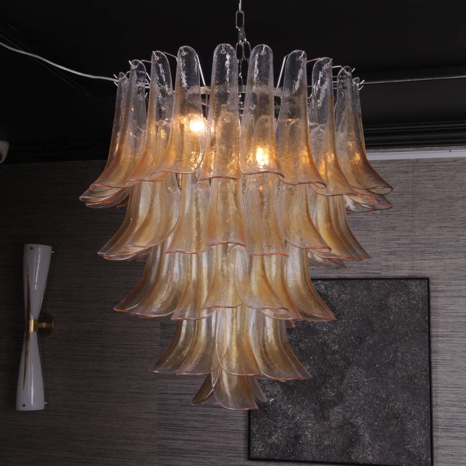 A five-tier chandelier made using original 1970s Murano glass which has been re-appropriated onto a new chrome frame.
Each petal was handblown giving a beautiful ripple detail to each piece, with an iridescent gold finish to the surface of the