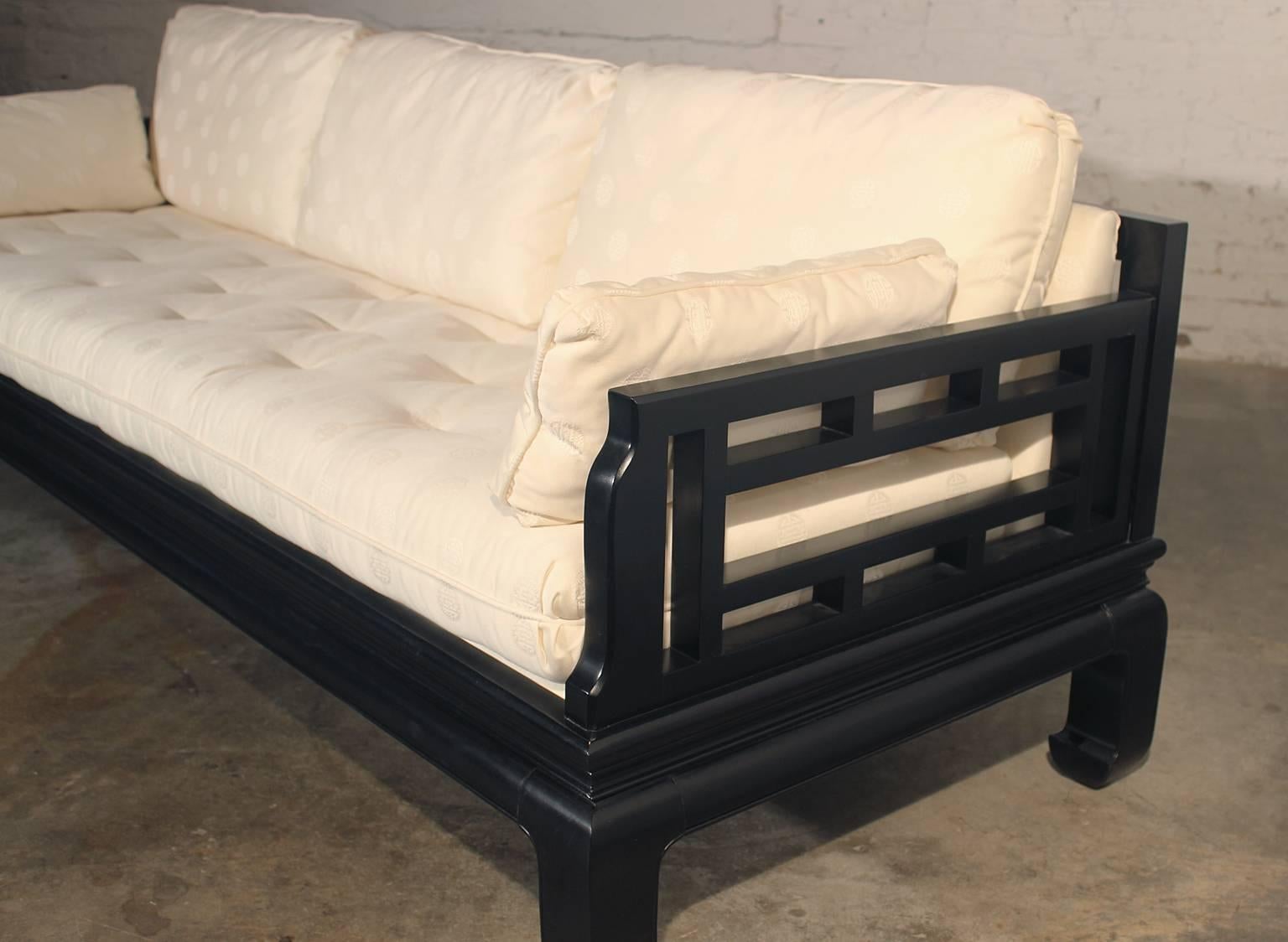 This is a dream sofa! Attributed to Michael Taylor for Baker and Asian inspired. This fabulous vintage sofa has a black lacquer Ming style frame and base with Chinese Chippendale style fretwork in the open arms and back. The white Asian upholstery