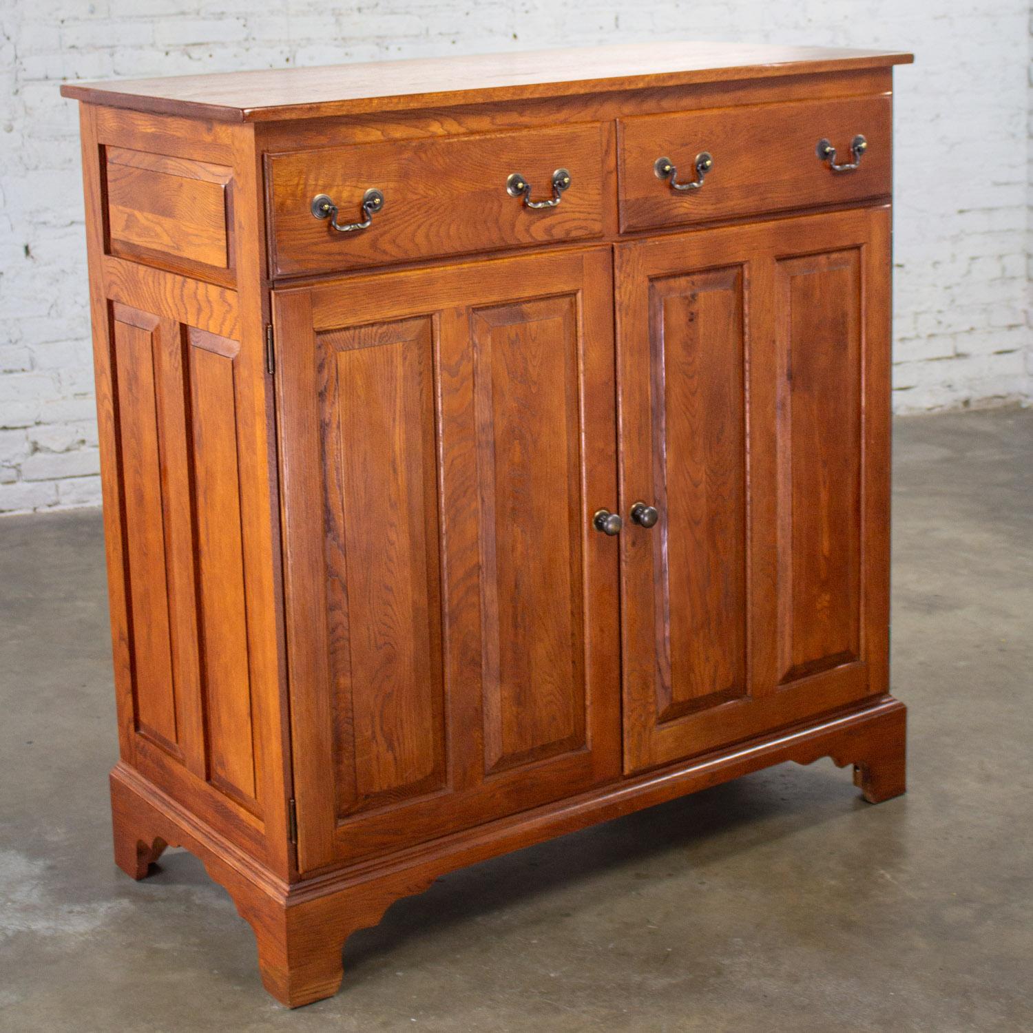 Fabulous 1995 Georgian style solid oak server cabinet or sideboard from the Chestnut Creek Collection 100 Year Anniversary Edition by Keller composed of solid oak, antiqued brass hardware, & dovetail drawers. Beautiful condition, keeping in mind