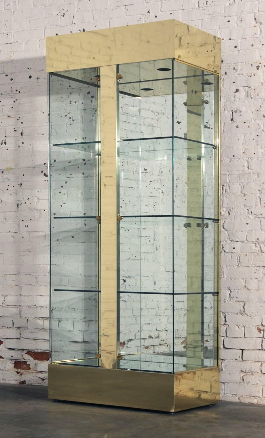 Perfectly awesome vintage modern brass, glass and mirror lighted display cabinet or vitrine, circa 1970s and in wonderful condition.

This awesome vintage modern brass and glass lighted display or vitrine cabinet would be a great way to display