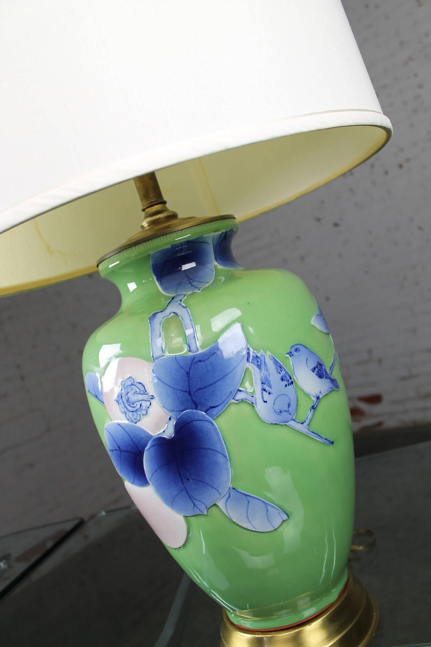 Large and gorgeous 1960s vintage ceramic vase style lamp in apple green with Asian-like design of birds, branches, leaves and fruit in blue and lavender. It is in wonderful vintage condition with no chips, cracks or crazing. The original shade is