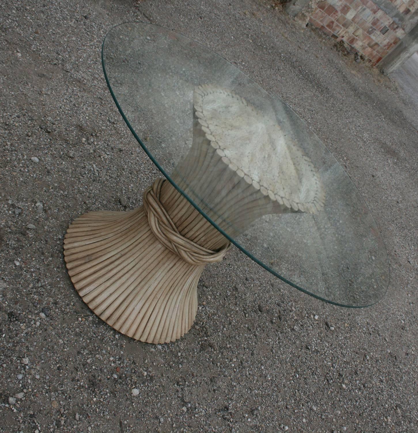 Vintage round sheaf-of-wheat style rattan dining or game table by McGuire Furniture. Table is in wonderful vintage condition with normal wear and tear. The glass top is free of chips but may have some small scratches which come with age.

Here it