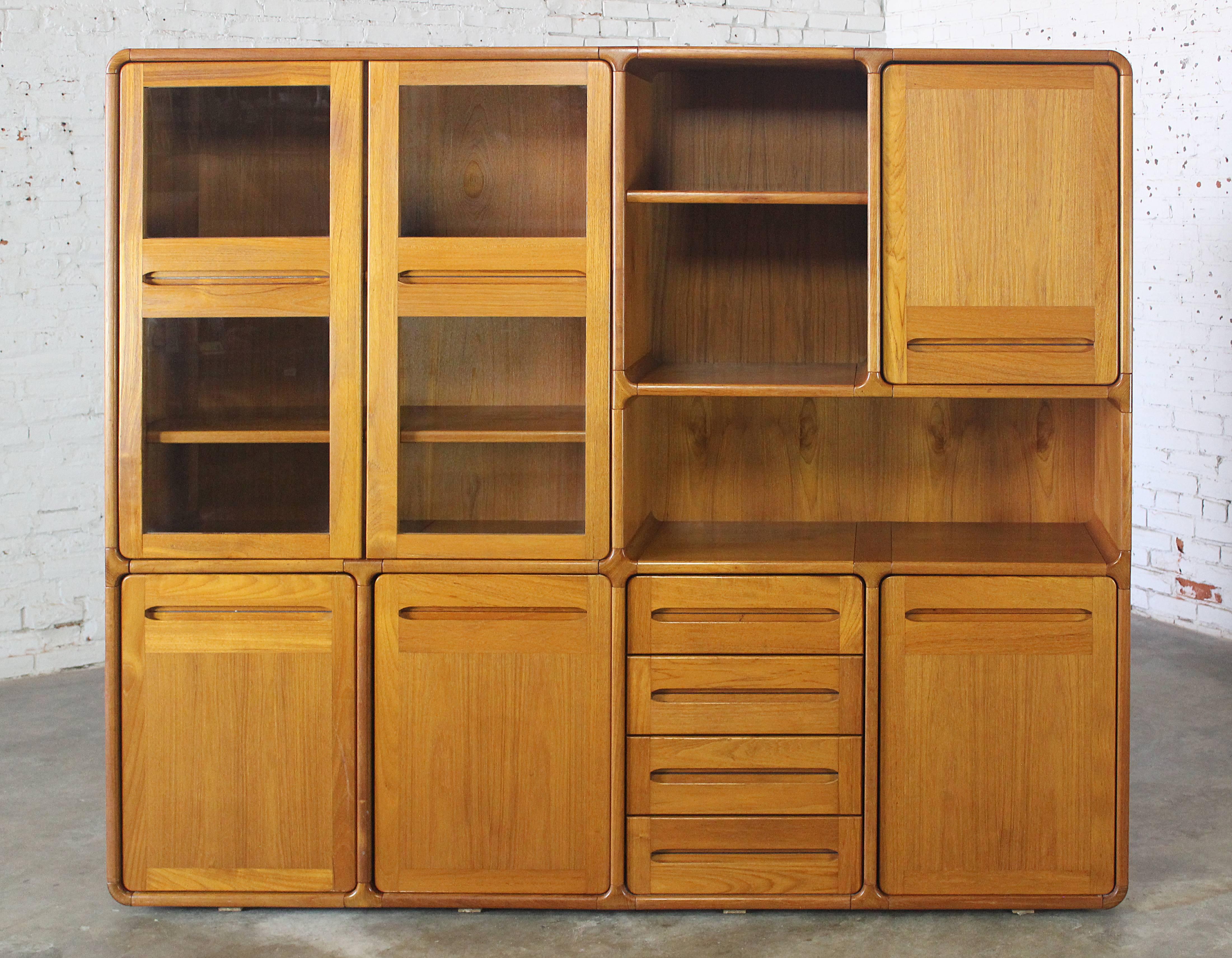 Very nice teak wall unit bookcase, display, and storage cabinet in the Dyrlund Scandinavian Modern style of the 1970s. It is in great vintage condition.

This is an awesome vintage Scandinavian Modern wall unit with both open and closed display