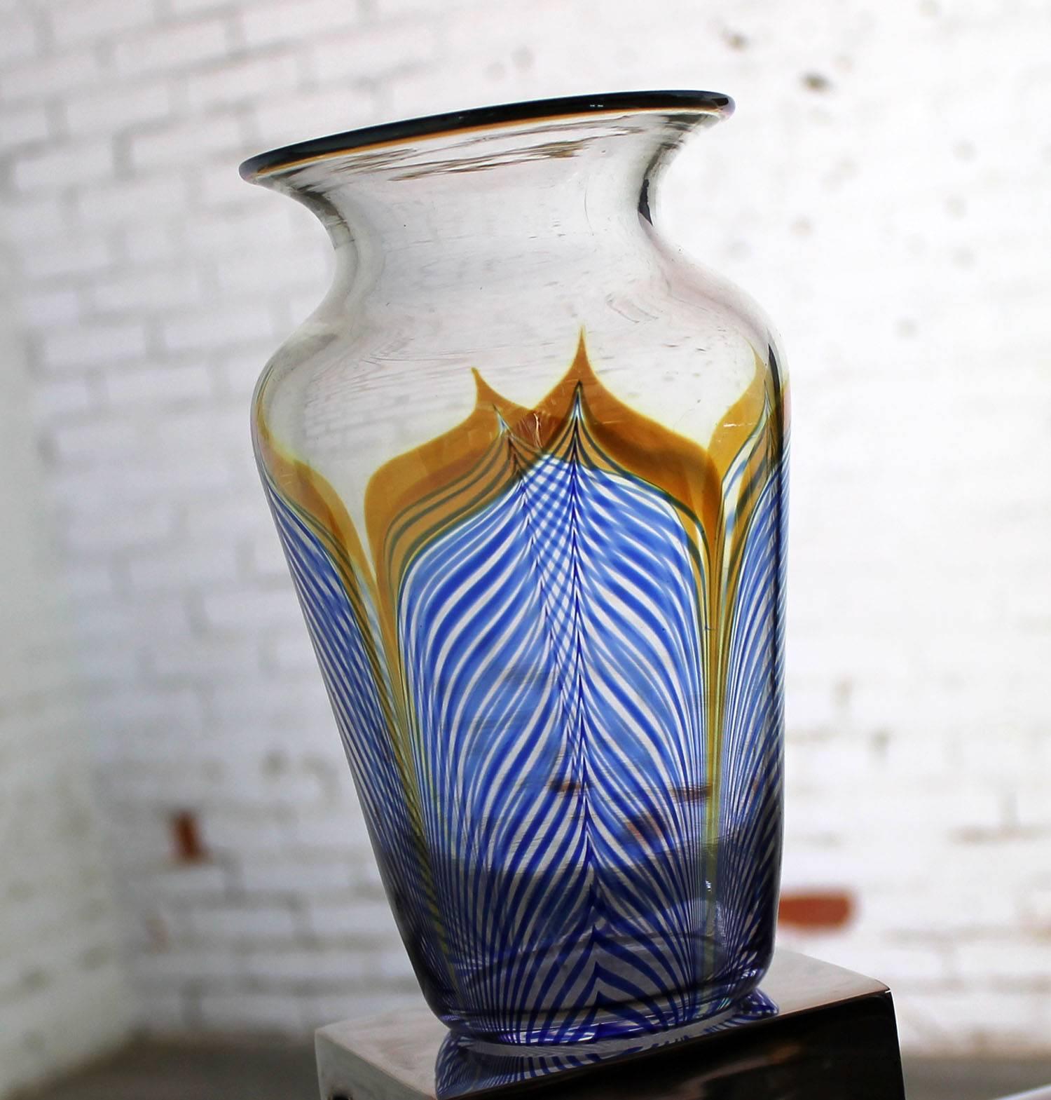 Gorgeous piece of Correia art glass in cobalt, metallic and clear with a pulled feather design. This vase is in wonderful vintage condition.

This gorgeous vase is vintage Correia art glass. Done at a time before Steven turned the helm over to his