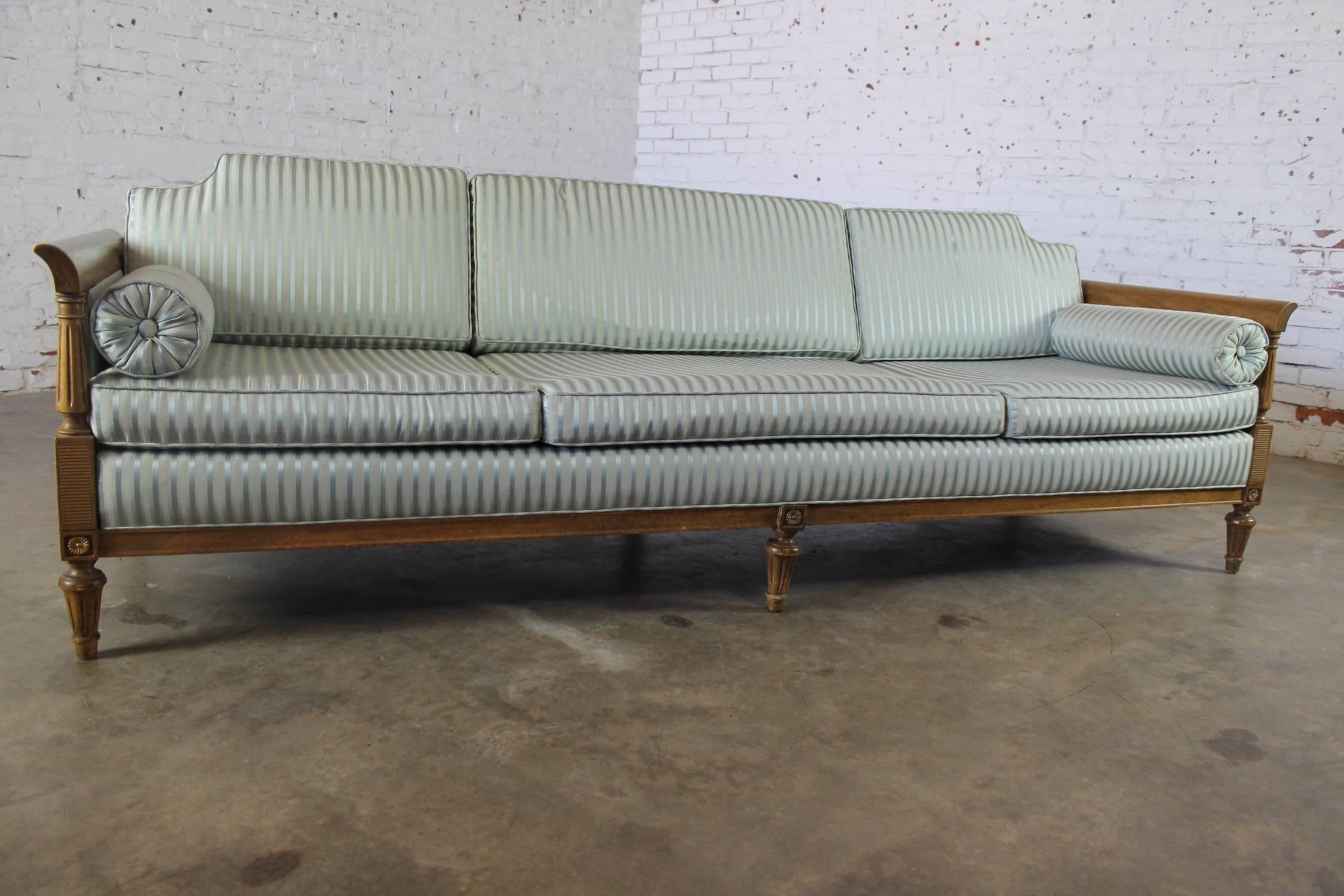 Fabulous Hollywood Regency/neoclassic sofa with caned arms and turned legs. This sofa is circa 1960 and in wonderful vintage condition.

This is an awesome vintage neoclassic Hollywood Regency sofa, circa 1960. It is stately but also rather