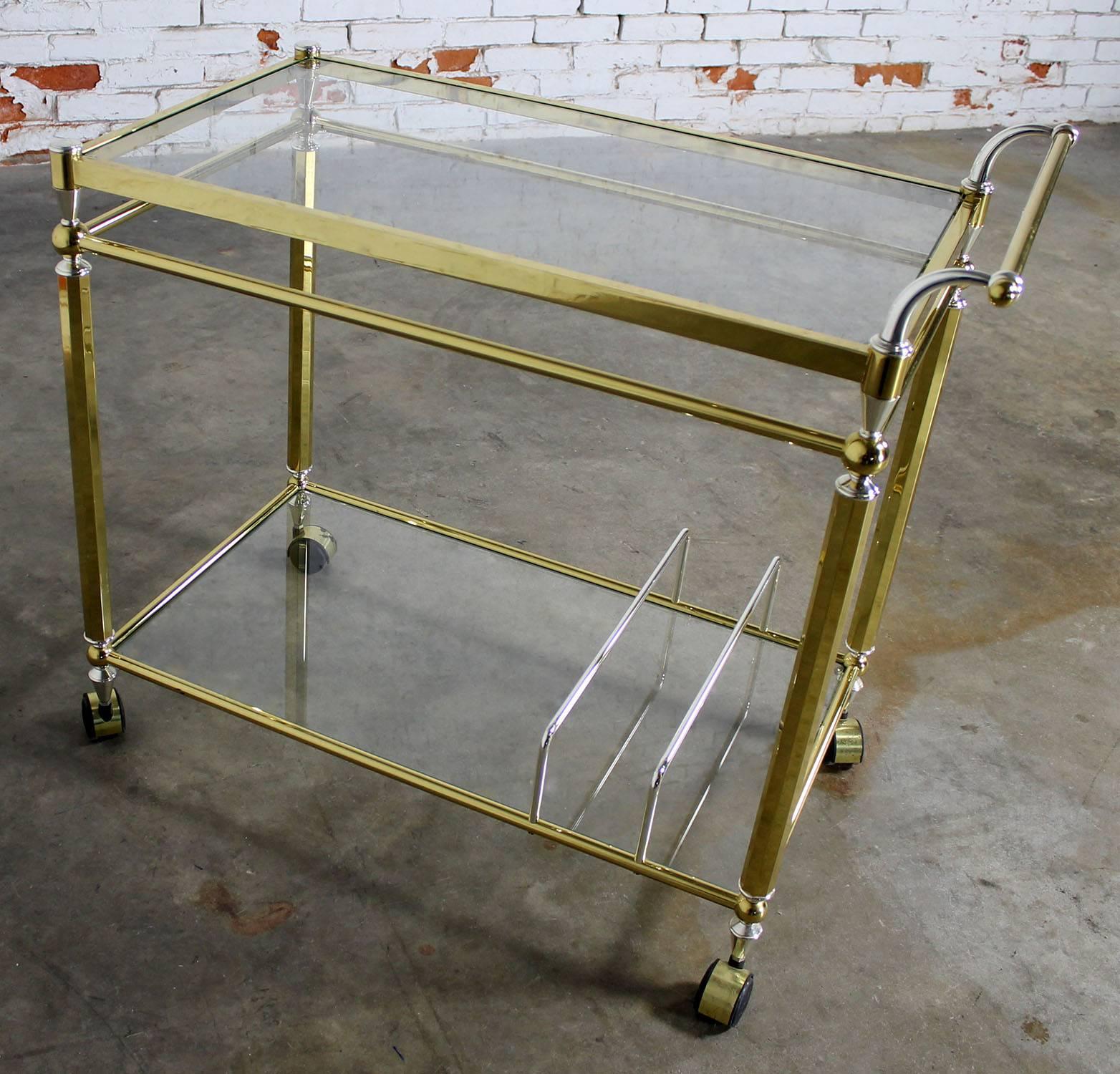 Elegant double-tier brass rolling serving, tea, or bar cart with glass shelves, circa 1970 and in excellent condition.

This is just the right bar cart, tea cart, or serving cart. With its combination of brass, chrome and glass materials and its