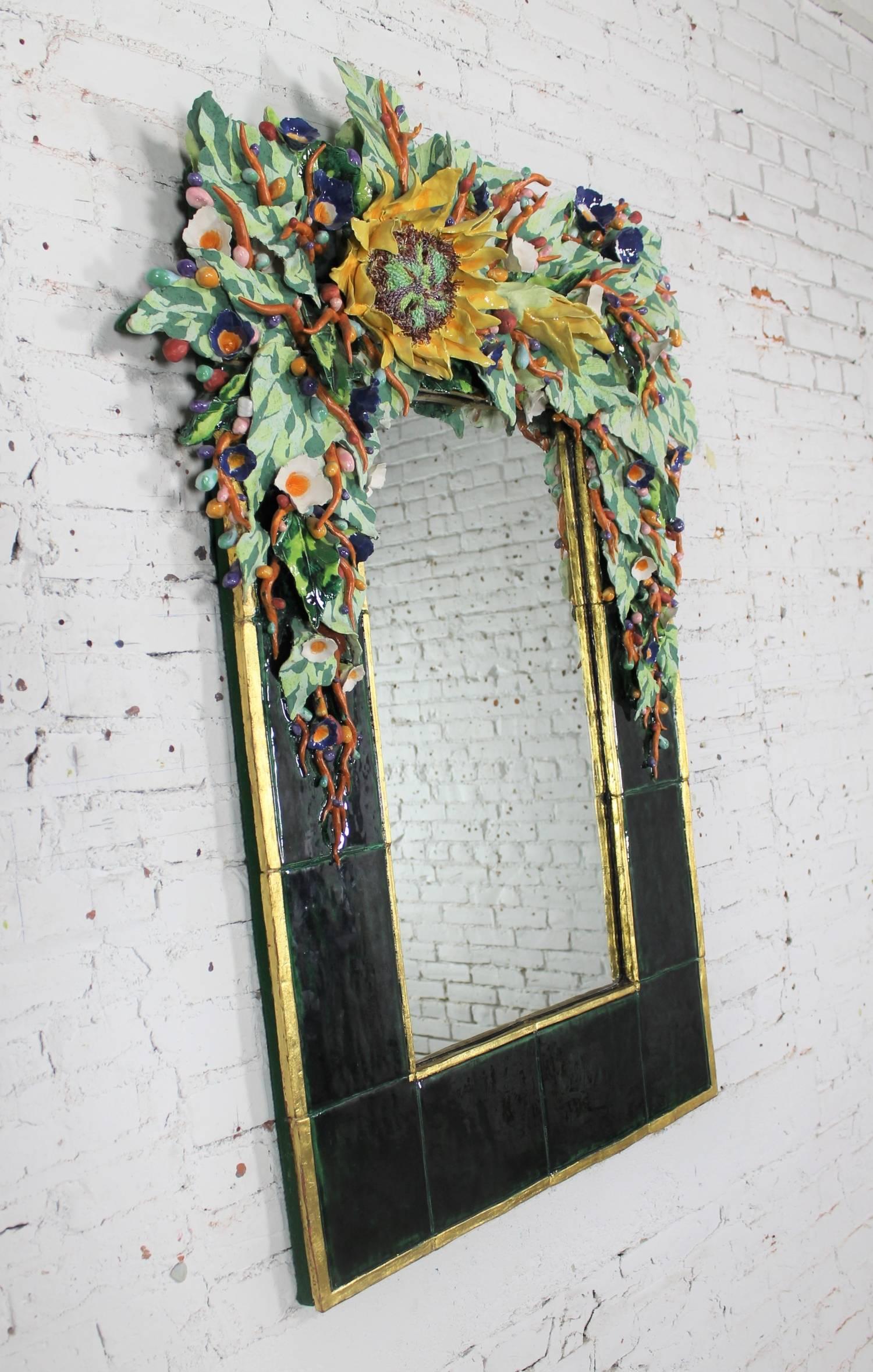 Extraordinary contemporary ceramic mirror by George Alexander with brightly colored three-dimensional floral design. It is in wonderful vintage condition. There is one minor chip on the left bottom corner that has been repaired.  Circa Late 20th