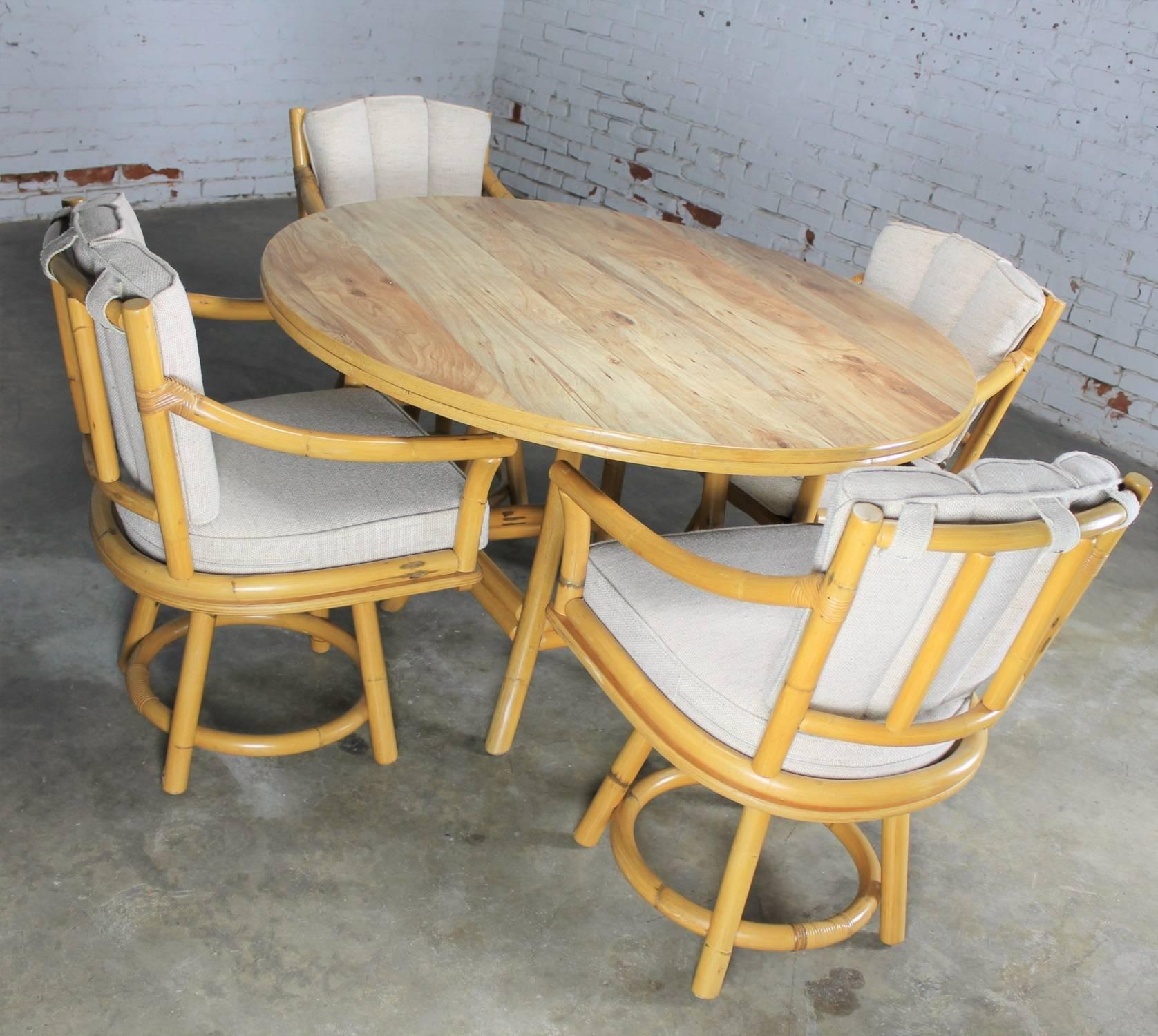 Perfect for your Florida room, a Mid-Century Ficks Reed Co. round game table of rattan with wood grain laminate top and four swivel armchairs of rattan with oatmeal colored hopsack fabric cushions. This awesome set is in exceptional circa 1970
