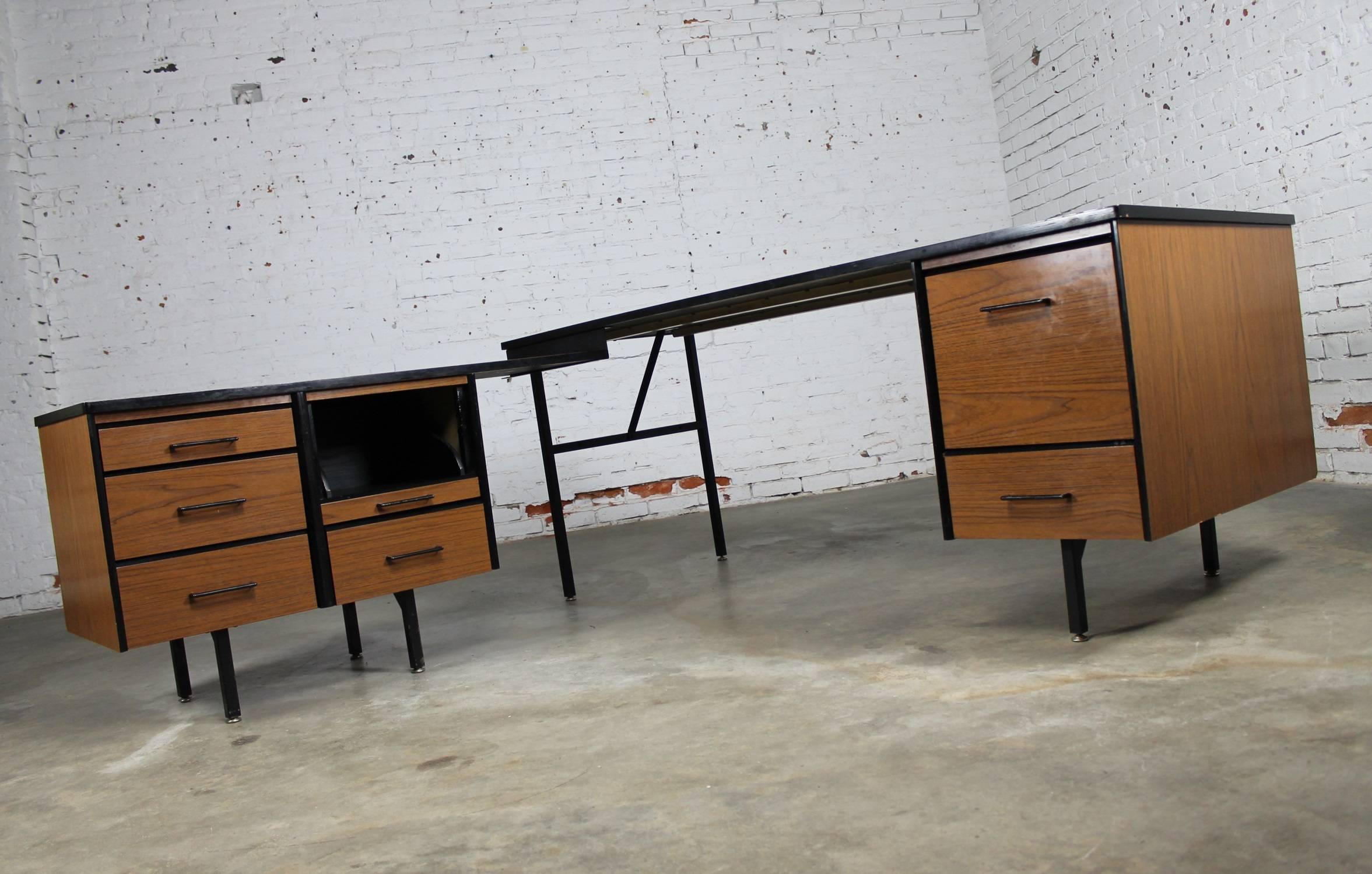 Incredible Mid-Century Modern imperial desk company desk with return. Done in walnut laminate with black metal legs and accents in the style of Florence Knoll for Knoll or George Nelson for Herman Miller and in good vintage condition, circa