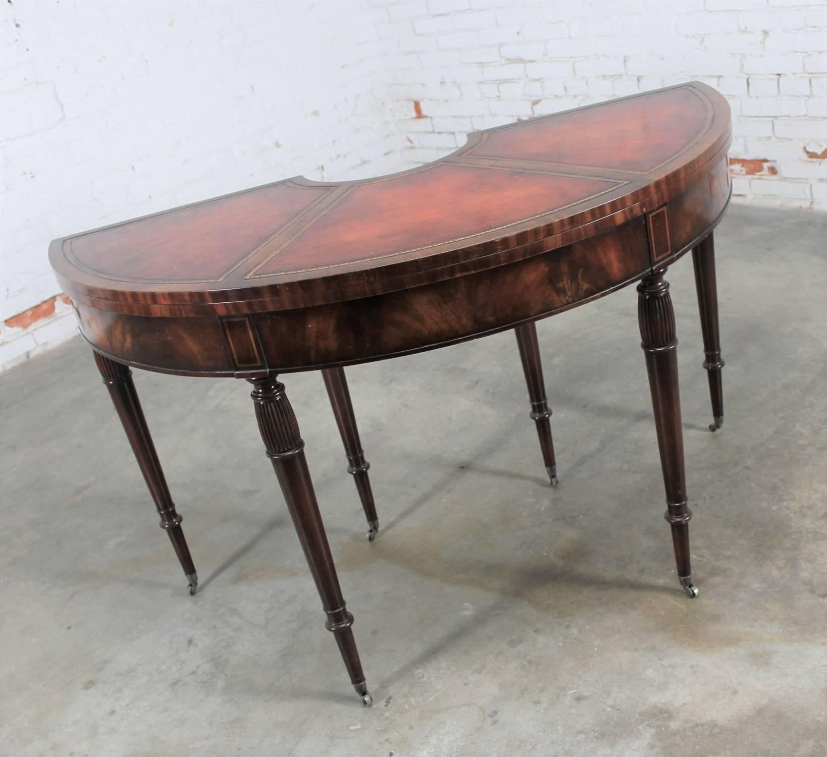 Gorgeous Federal style demilune console table or game table in mahogany with banded leather flip-top and turned and tapered legs. In wonderful vintage condition, circa 20th century by Weiman Heirloom quality tables.

This is a beautifully made