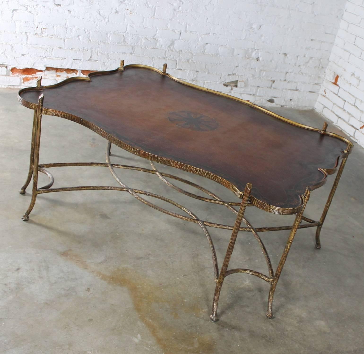 Gorgeous gilded or antique gold finished faux bois iron coffee table in chinoiserie or Hollywood Regency style with tole painted metal tray style top. In fabulous vintage condition, circa 1990.

This stunning gilt iron faux bois coffee table