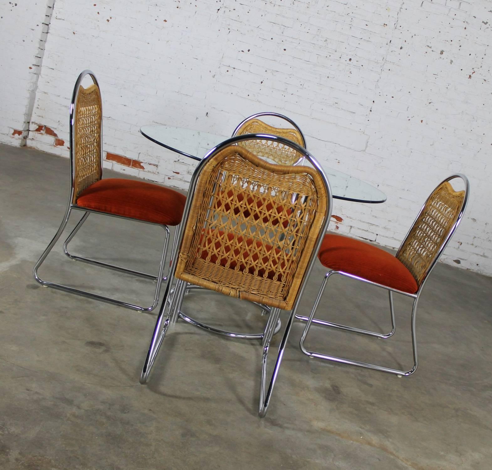 Fabulous vintage Modern dinette set by Daystrom Furniture featuring a round glass top chrome base table and four chairs with arched top chrome frames, wicker inset backs, and orange fabric upholstered seats, circa 1980 and in great vintage