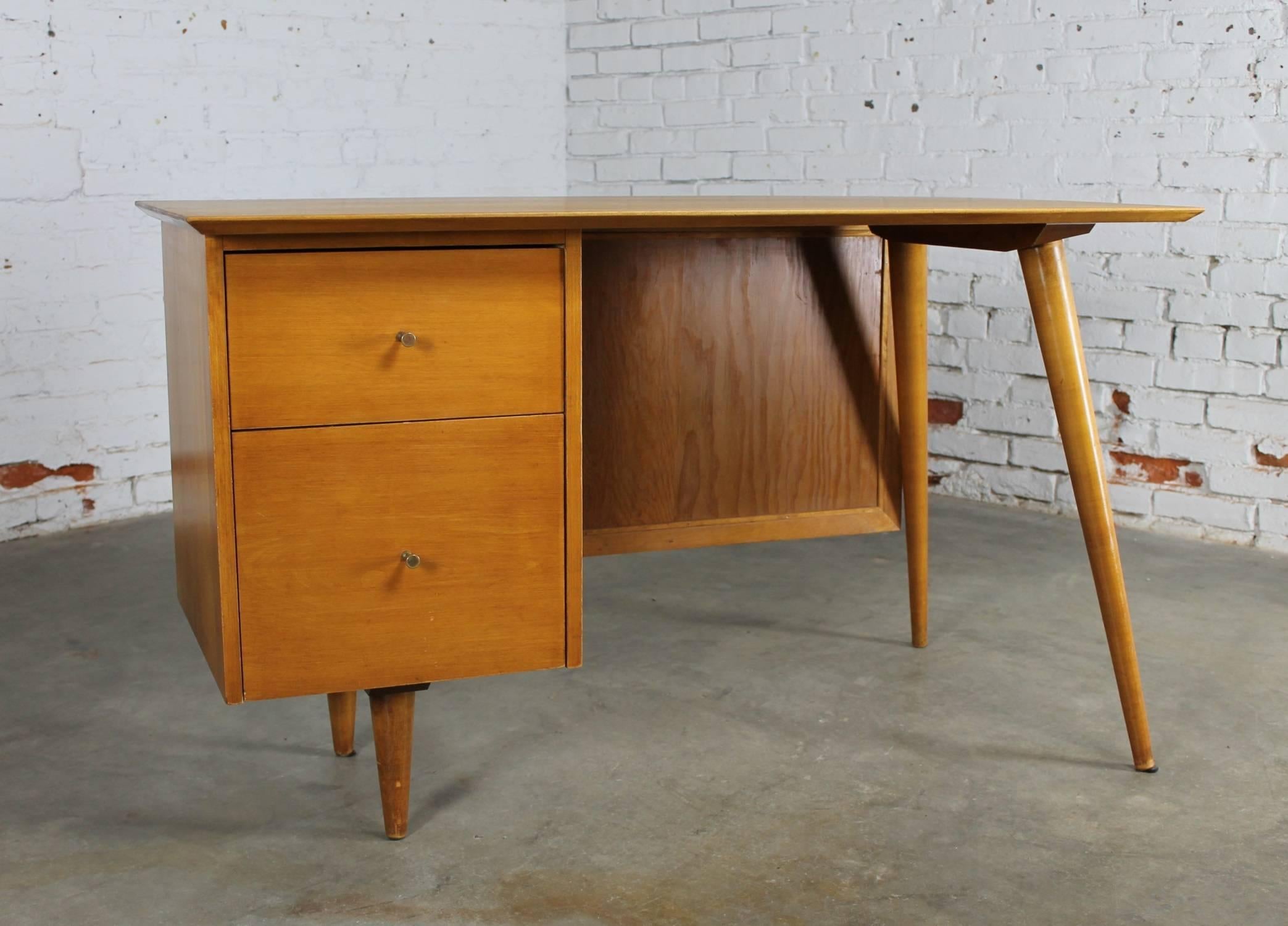 Iconic Mid-Century Modern writing desk from the Planner Group by Paul McCobb for Winchendon. In natural maple with an added cane modesty panel. It is in wonderful vintage condition with the finish on the top having been restored.

This fabulous