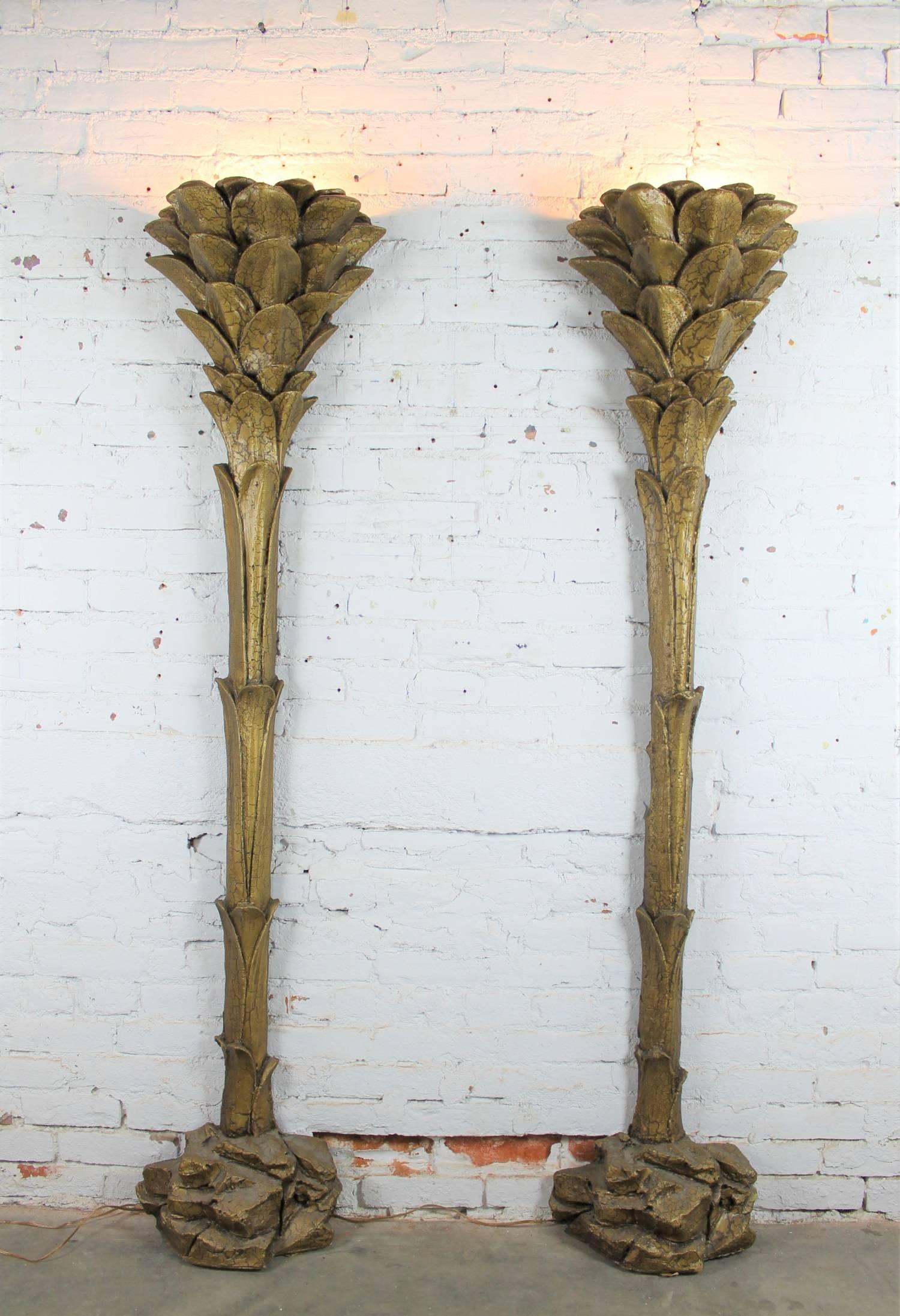 Outstanding gilded polystyrene foam palm tree floor torchiere style wall sconce lamps in the style of Serge Roche. The pair are in wonderful vintage condition, circa 1970.

Fabulous and over-the-top! I’m not sure what style to call this pair of