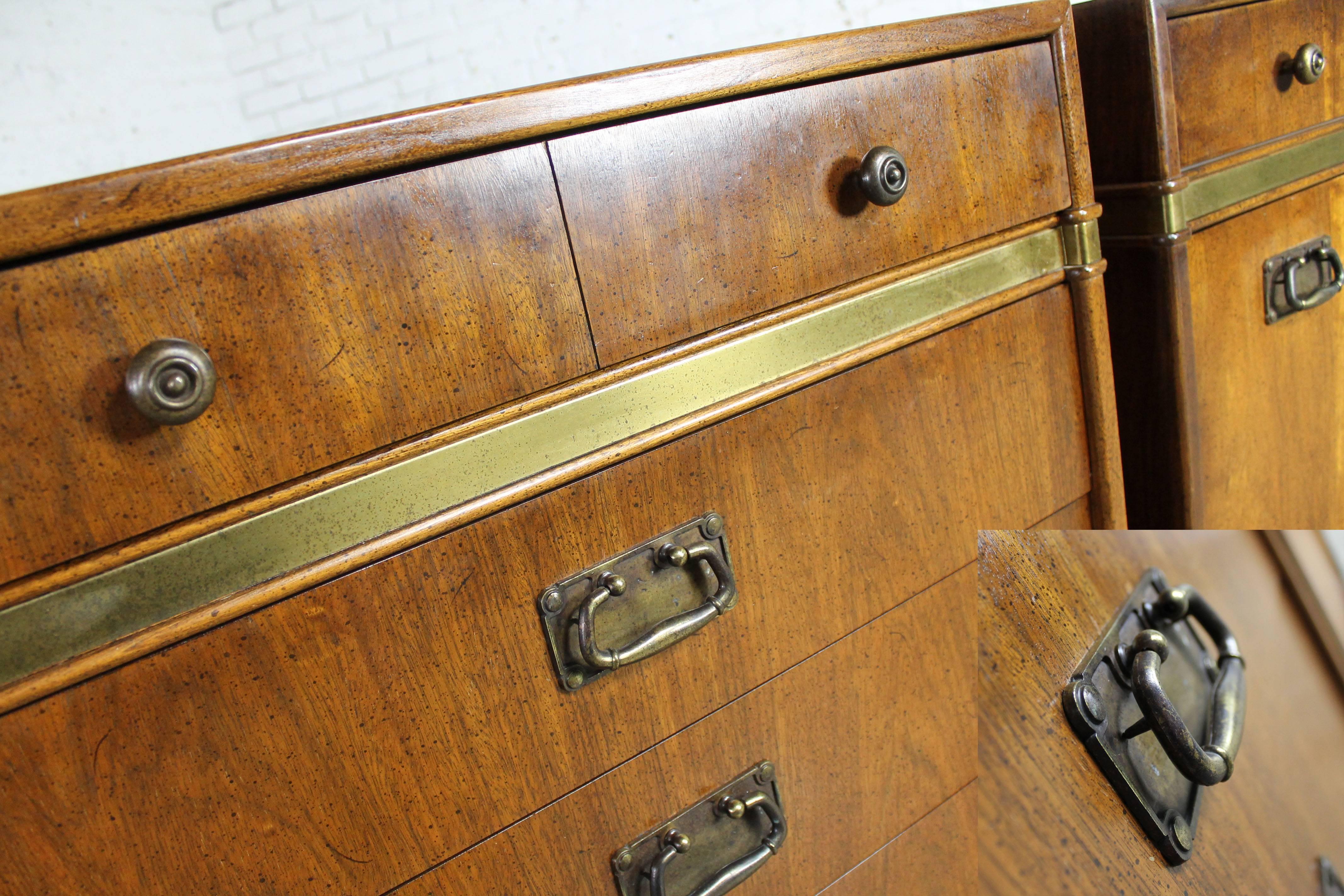 Fabulous pair of Campaign style chests by Hickory Manufacturing Co. with antiqued brass trim and hardware. The pair are in wonderful vintage, circa 1970s condition. 

Looking for a pair of outstanding bedside chests? Look no further. These