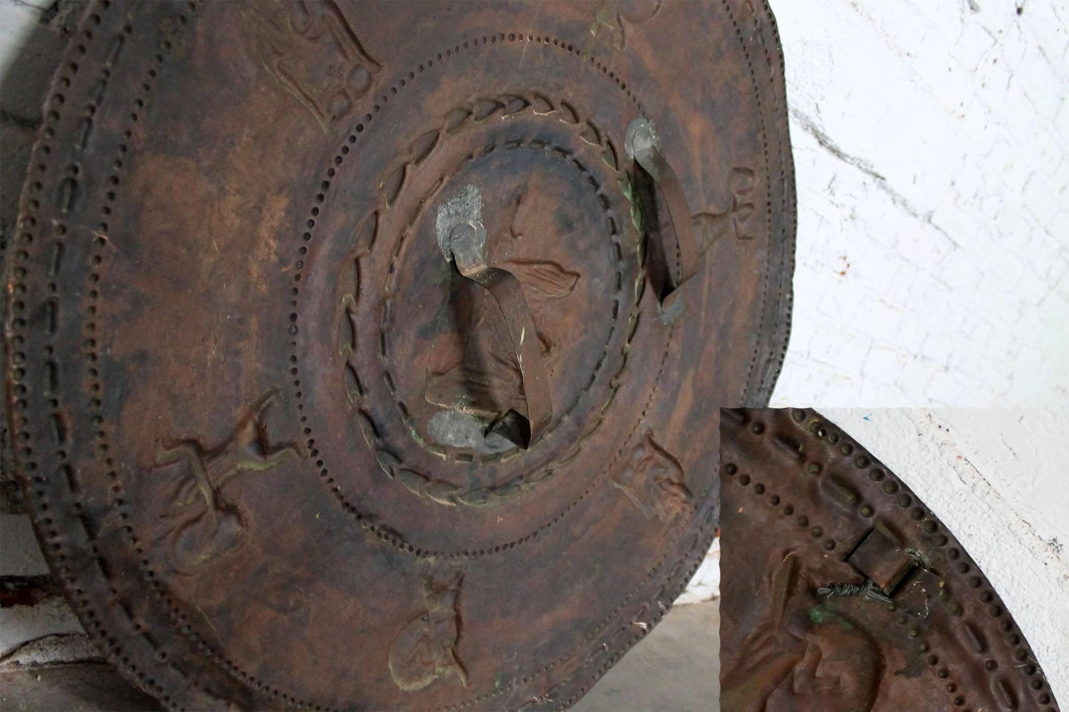 Fun and unique wall décor. Warrior shield and spears purportedly used in a silent film, circa 1930. They are in ready to hang condition.

How fun are these? Heavy copper shield with embossed figures and spears which hang in an X-shape. This unique