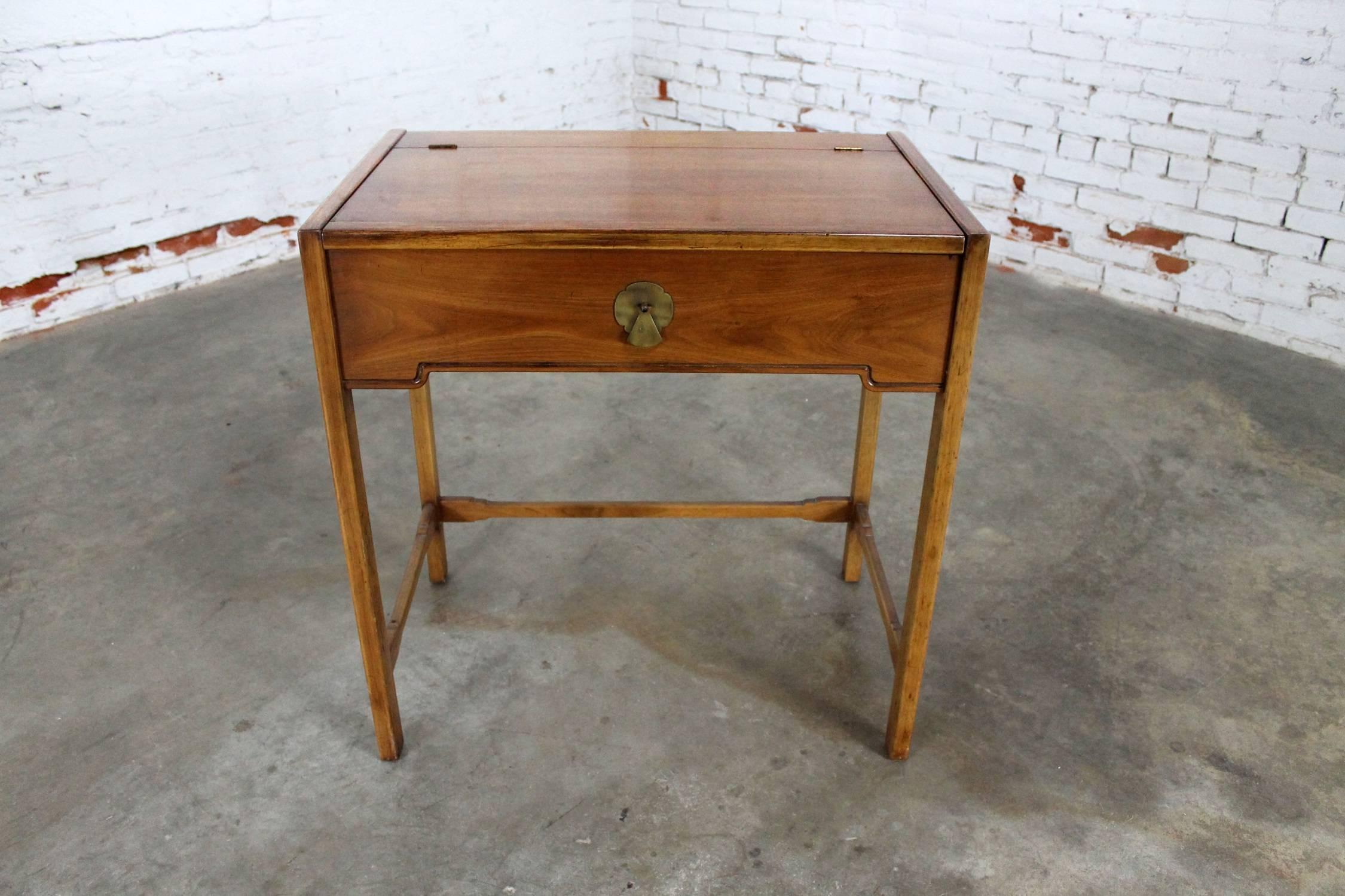Interesting and wonderful vintage Mid-Century Campaign style lift top make-up vanity with mirror by Drexel from their compass collection. In great vintage condition, circa 1960s but with nicks and dings as you would expect with its age and