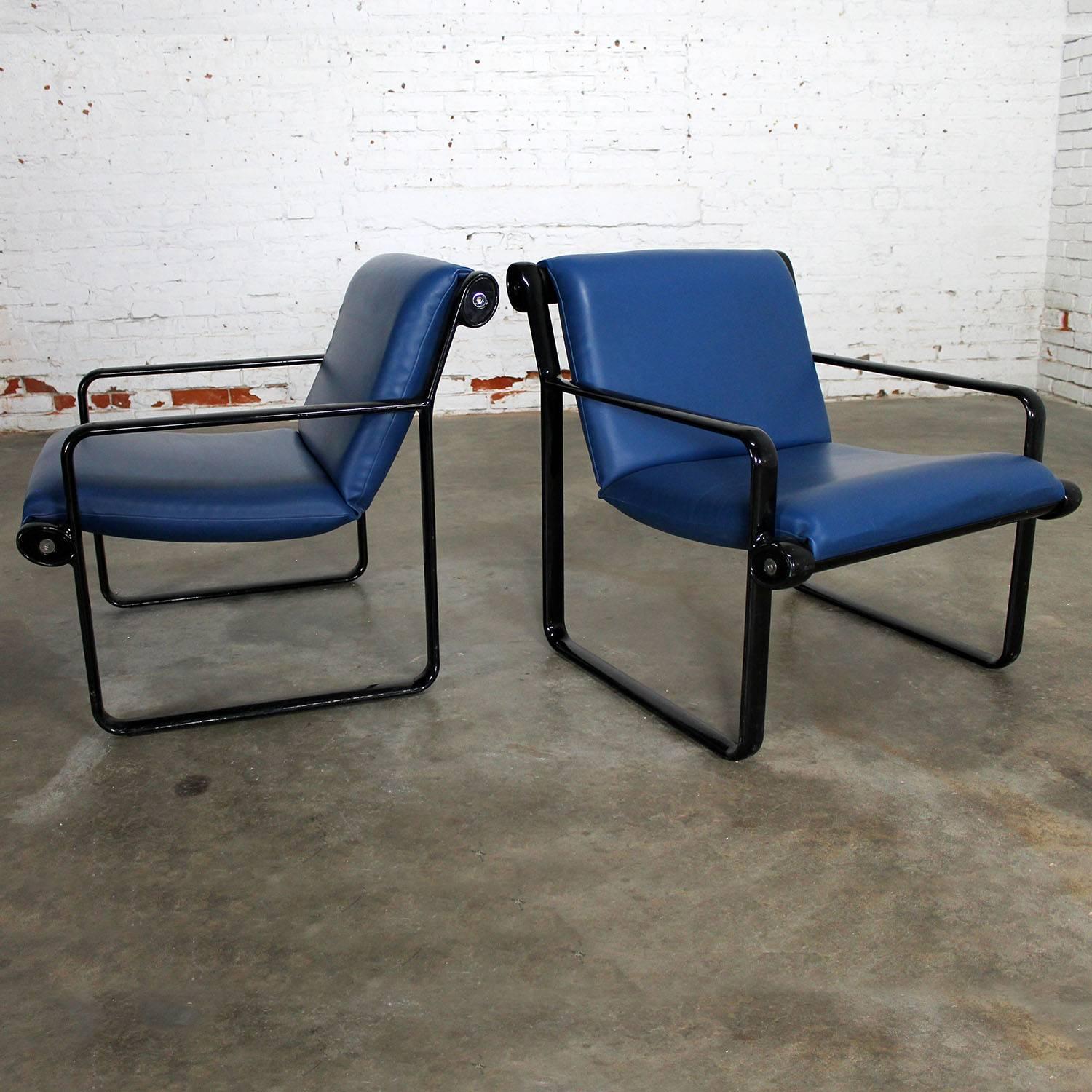 Handsome pair of sling armchairs designed by Bruce Hannah and Andrew Morrison circa 1971 for Knoll International, Inc. This pair is in wonderful vintage condition. The blue vinyl sling is soft with no visible flaws. The black frame does have some