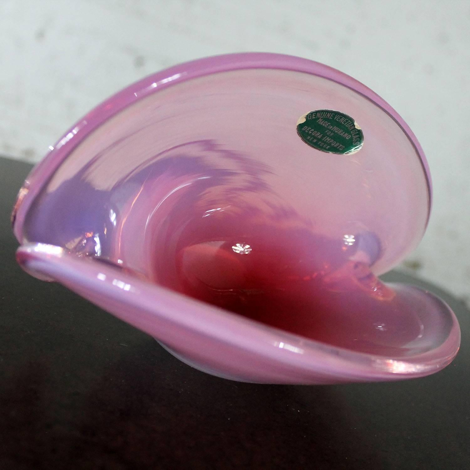 Fabulous opalescent pink clamshell Murano glass bowl with original sticker from Decora Import. Vintage Mid-Century Modern and in wonderful condition with no chips, cracks, or chiggers.

This beautiful pink and wonderfully luminous and opalescent