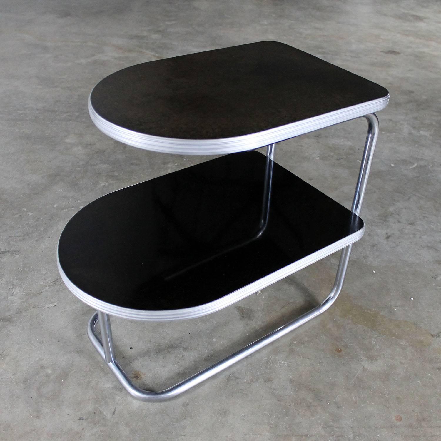 Fabulous, circa 1930s two-tiered streamline moderne machine age Art Deco chrome and black end table with Fireloid original surfaces. In wonderful vintage condition. The chrome and aluminum are in awesome shape and the lower surface is perfect;