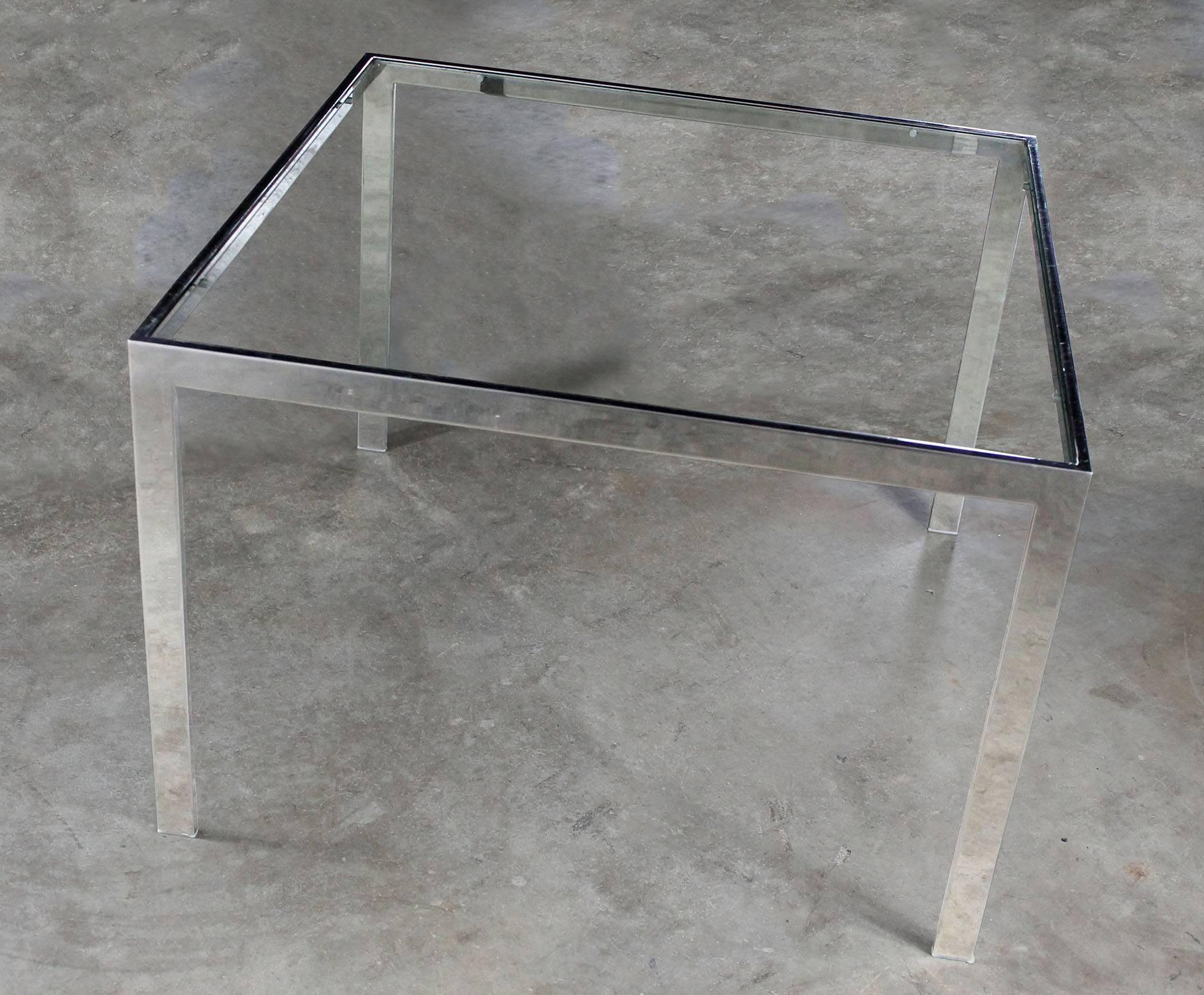 Handsome chrome and glass Parsons style end table attributed to Milo Baughman, circa 1970. In wonderful vintage condition with no outstanding flaws we have been able to detect. UPDATE: We have noticed there are small chips in the edges of the glass