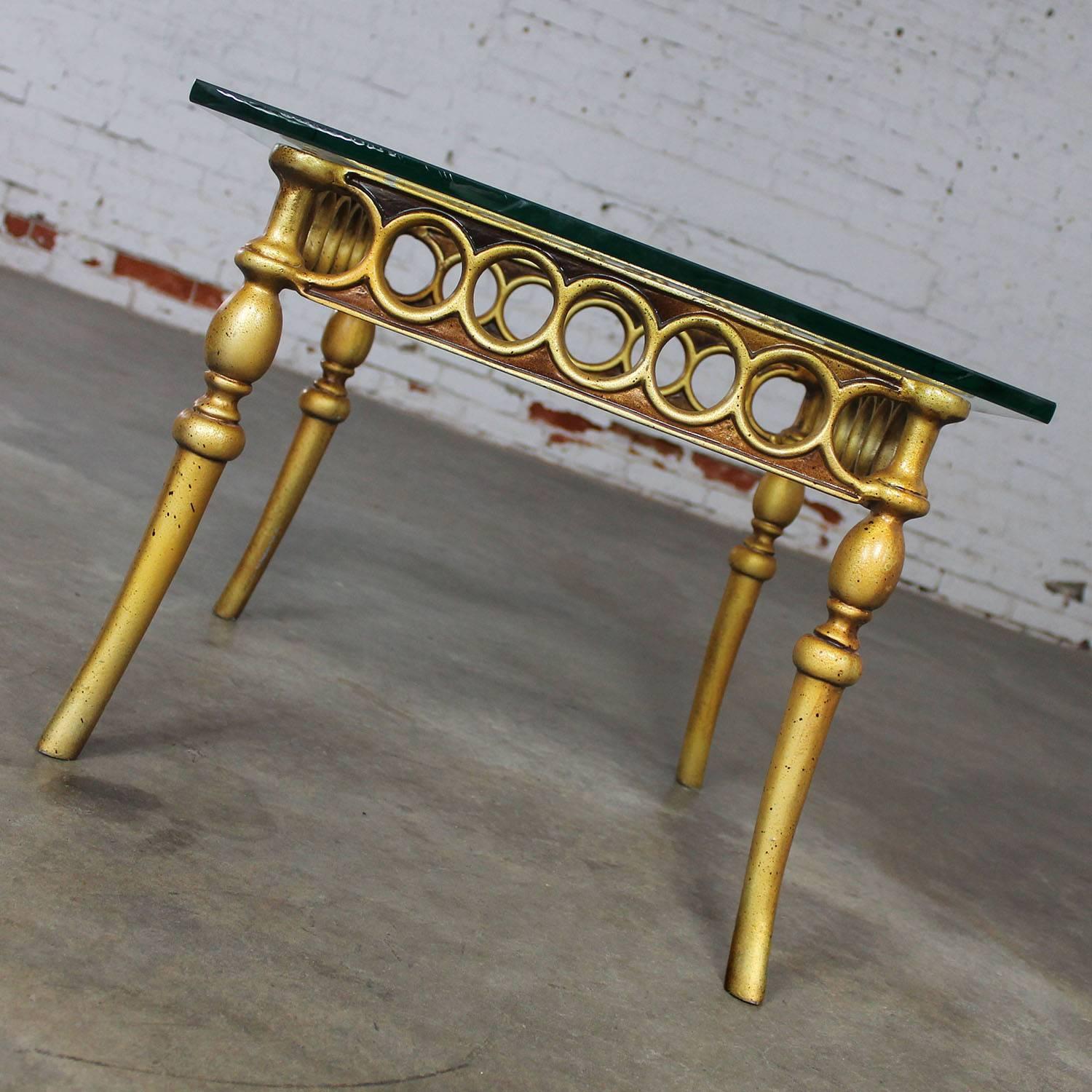 Wonderful little Hollywood Regency or Art Deco styled side or end table with glass topped base of gilded cast aluminum construction and fabulous, circa 1970s condition.

This is quite the awesome little accent table! Hollywood Regency or Art Deco
