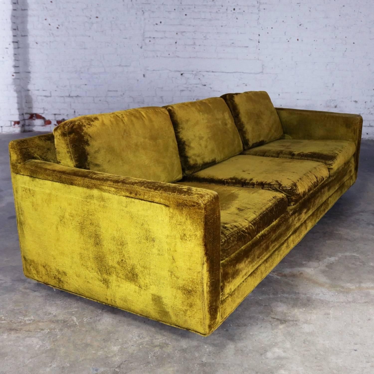 Slender and simple Lawson style three-cushion sofa in green velvet upholstery. This vintage sofa is circa 1960s and the frame is in wonderful condition. The foam is soft in the cushions but could use some additional padding; and, the fabric is worn