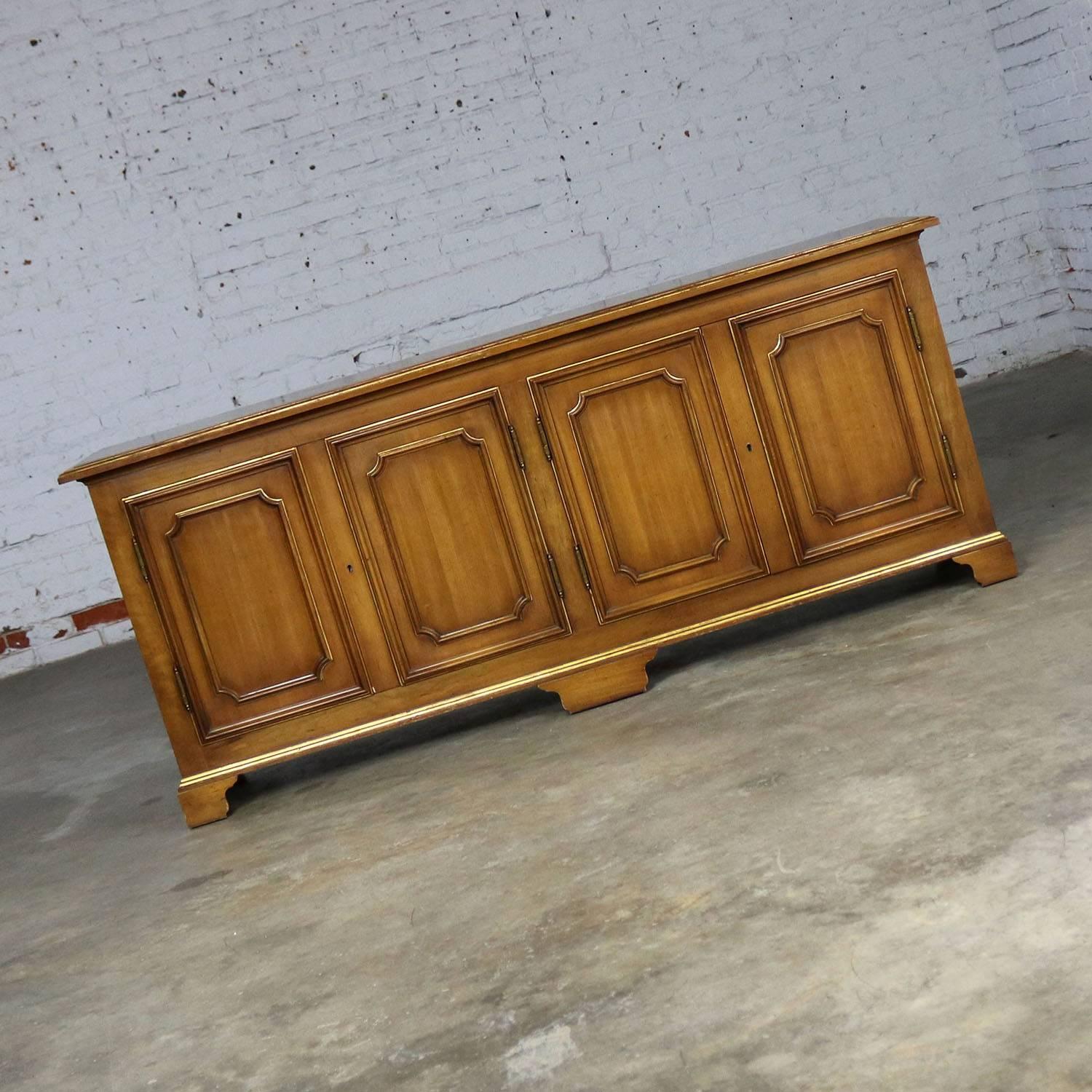 Handsome painted Hollywood Regency buffet credenza cabinet with gold aka gilt accents by John Widdicomb furniture company. In wonderful original vintage condition with a few nicks and dings that only add beauty to the patina. Please see photos.