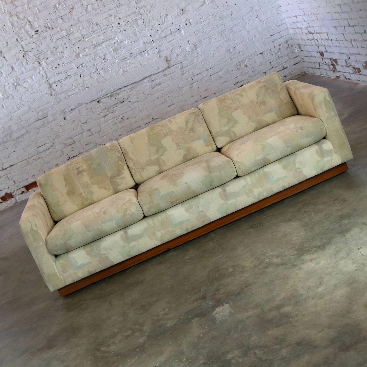 Wonderful floating tuxedo style sofa done in the manner of Milo Baughman for Thayer Coggin. This sofa is in great vintage circa 1970s condition. There are some chips to the veneer on the bottom edge of the recessed platform base; however, they are
