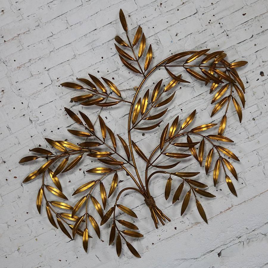 Gorgeous Italian Hollywood Regency wall sculpture of gilt metal branches with leaves. In fabulous vintage mid century condition circa 1960s and retaining its original Made in Italy tag.

This incredible wall sculpture was made in Italy, circa