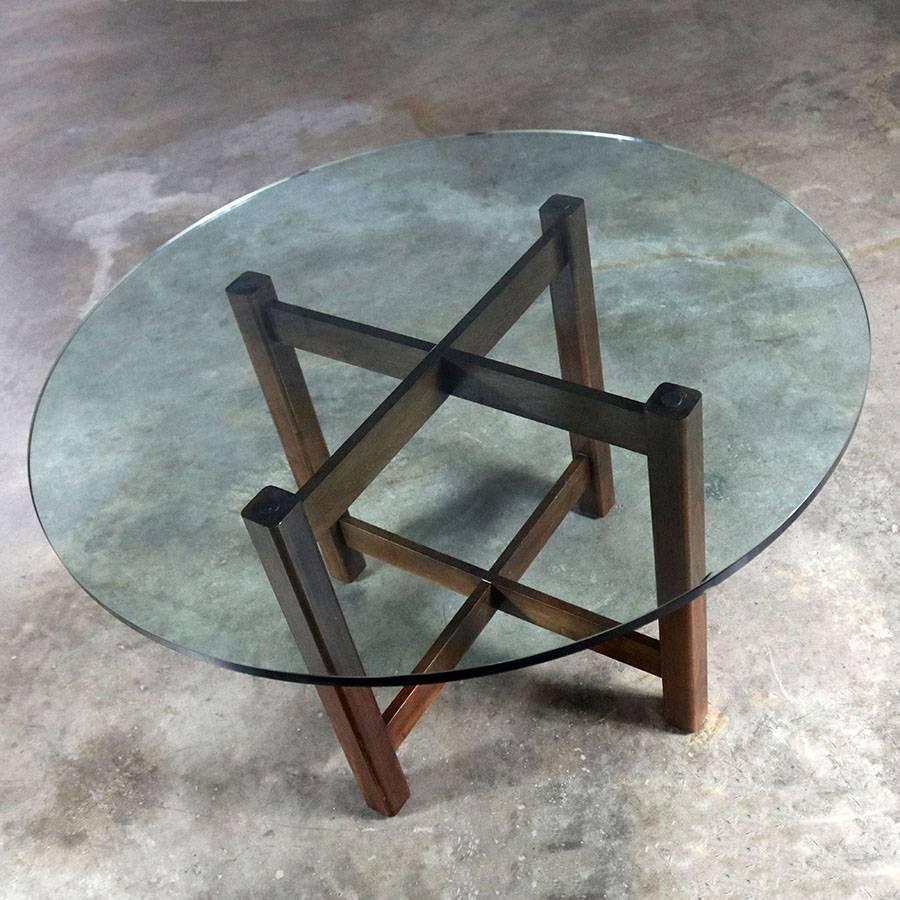 Handsome and chunky X-base modernist round glass top dining room or game table. Wonderful vintage condition with normal wear and tear but nothing major, circa mid-late 20th century. There is an edge chip to its beautiful ¾ inch glass top.

Looking