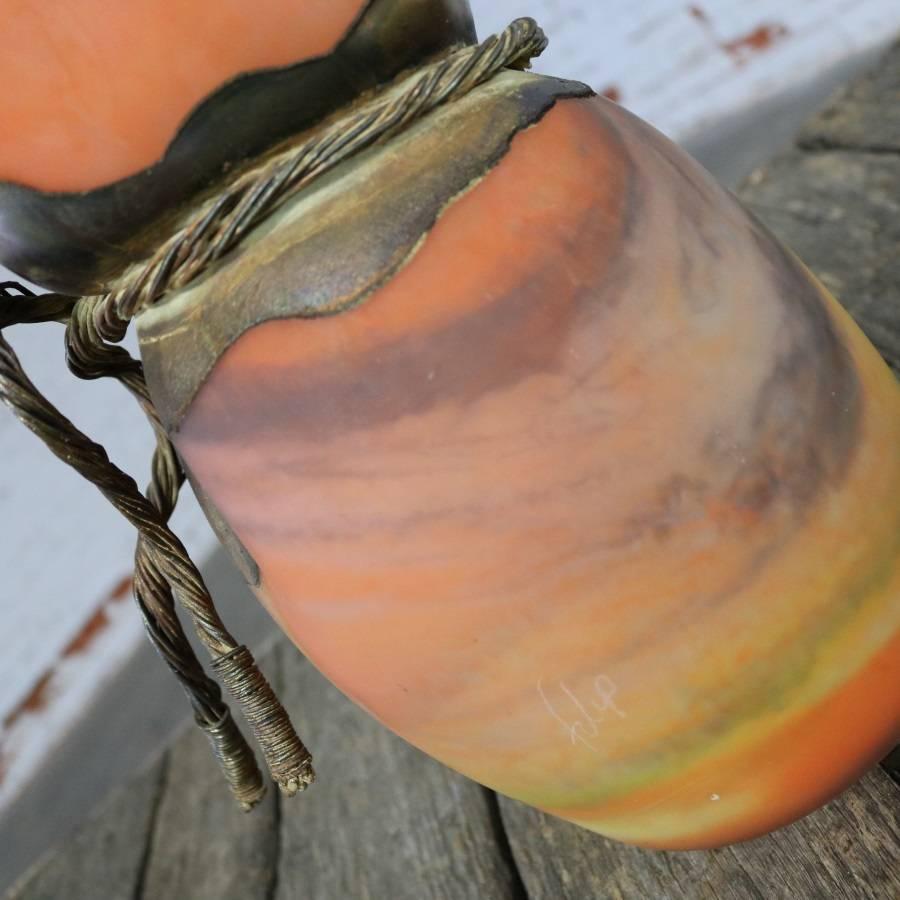 Awesome orange, yellow and brown blown slag glass vase by Filip Ravert. Monumental in size and presence and signed Flip. The waist is cinched with a metal wrap. The age is unknown; but, from what we have gleaned from online information plus its