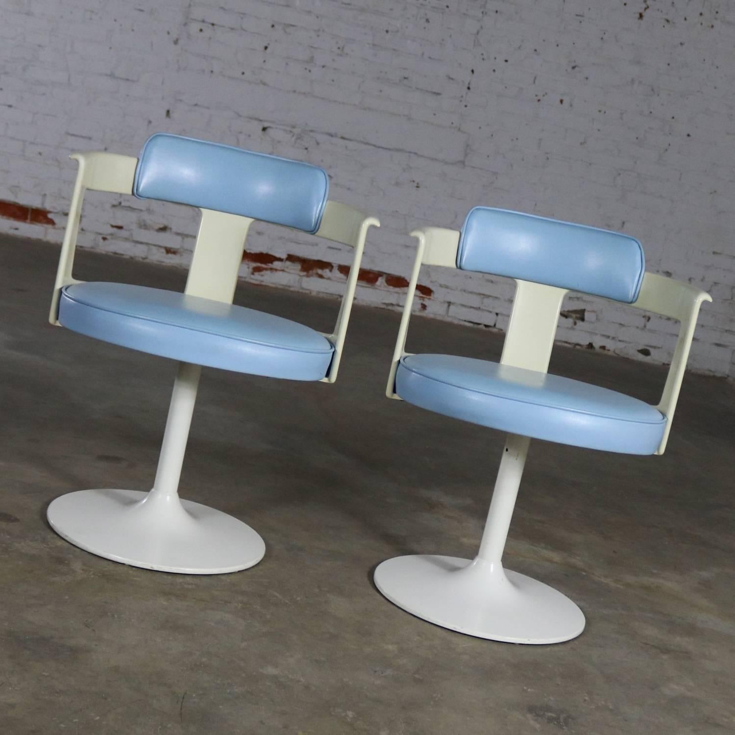 Awesome pair of Mid-Century Modern tulip style swivel chairs by Daystrom Furniture in their original baby blue vinyl upholstery white plastic arms and frame and white painted metal bases. They are in wonderful vintage condition. There is a slight